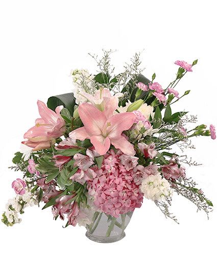 Breathtaking Blush Floral Design - This stunning bouquet sure is sweet! Featuring a dazzling array of pink hydrangeas, lavender mini carnations, white daisy poms, and more, Breathtaking Blush is full of elegance and grace. Send this delightful bouquet to the ones you love today!  Includes: Clear Ginger Vase, Greens: Variegated Pittosporum, Israeli Ruscus, Aspidistra, Flowers: Purple Alstroemeria,   Light Pink Lilies , White Stock, Pink Hydrangea, Lavender Mini Carnations, Purple Caspia.
