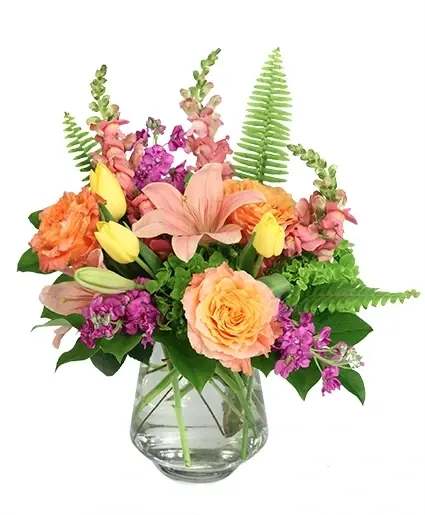 A Fruity Mix Vase Arrangement - What a sweet treat this bouquet is! Full of Free Spirit roses, snapdragons, tulips, lilies, and more in shades of pink, purple, yellow, and peach, A Fruity Mix is a citrus delight. Add some sweetness to your next occasion with this charming bouquet!  Includes: Pyramid Vase , Sword Fern, Salal, Green Hydrangea, Pink Lily , Free Spirit Roses, Pink Snapdragons, Purple Stock , Yellow Tulips .