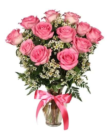 Primetime Pink Roses Arrangement - These bubblegum pink roses are a sweet treat for your delectable darling! Show your appreciation with a dozen pink roses perfect for Mother's Day, Valentine's Day, or any occasion.  Includes: Classic Urn Vase Foliage: Variegated Pittosporum, Leather Leaf , Bubblegum Pink Roses, White Waxflower , Medium Pink Ribbon.