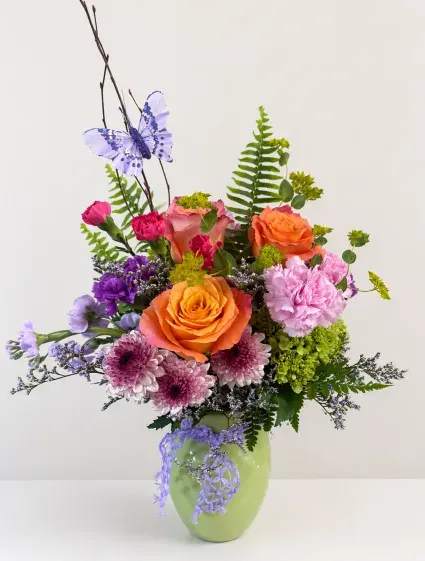 Lovable Flower Arrangement - Show how much the Mother in your life means to you by giving her this colorful, vibrant piece. Filled with an assortment of flowers and greenery any Mother is sure to feel appreciated by.
