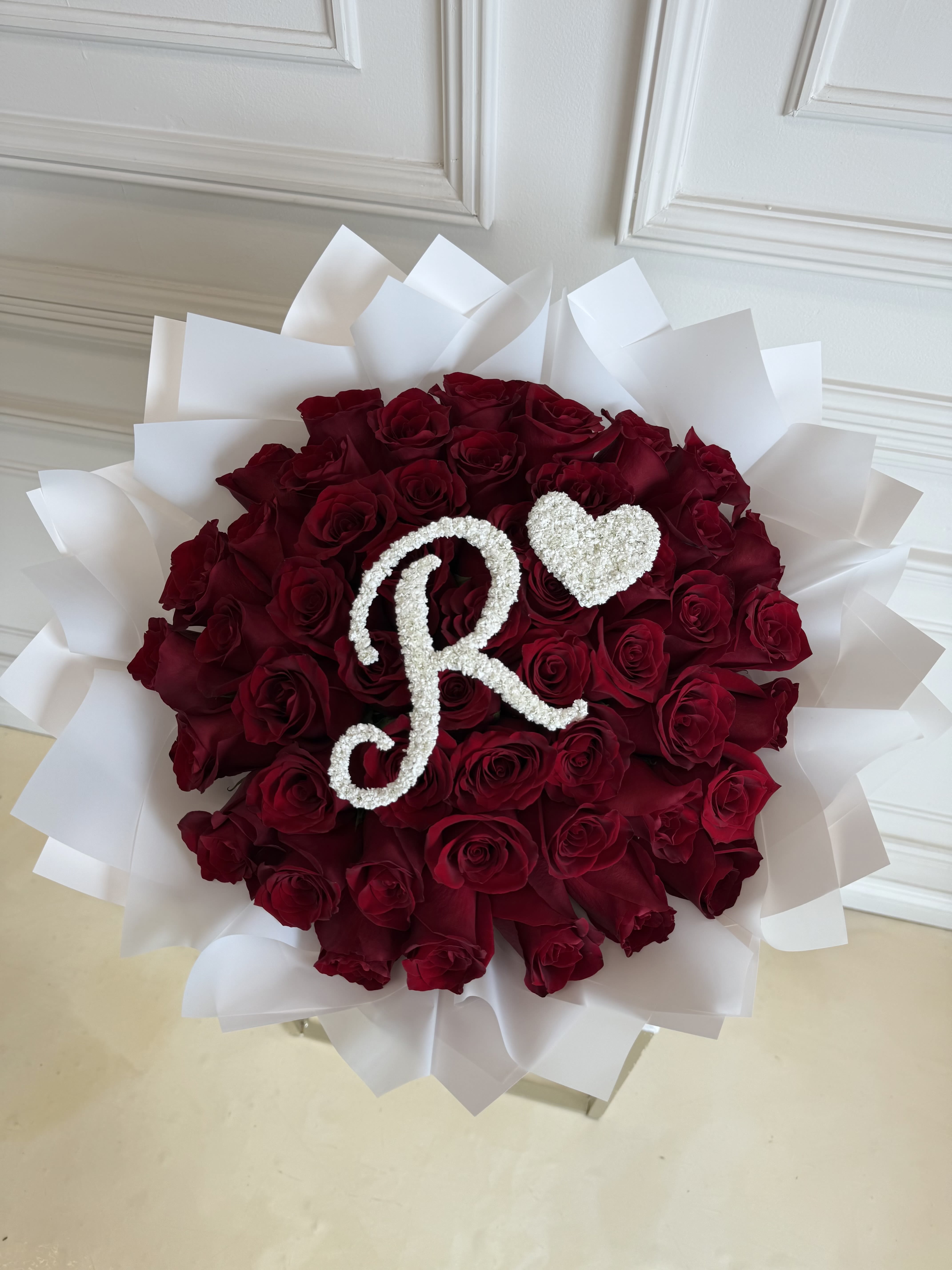 MFS 50 Rose Bouquet (Initial Design)  - 50 Red Rose Bouquet (Initial Design)   Under florist instructions/ special instructions please let us know what letter you would like on the bouquet.   Please note only 1 letter is allowed   *this bouquet does not include a glass vase 