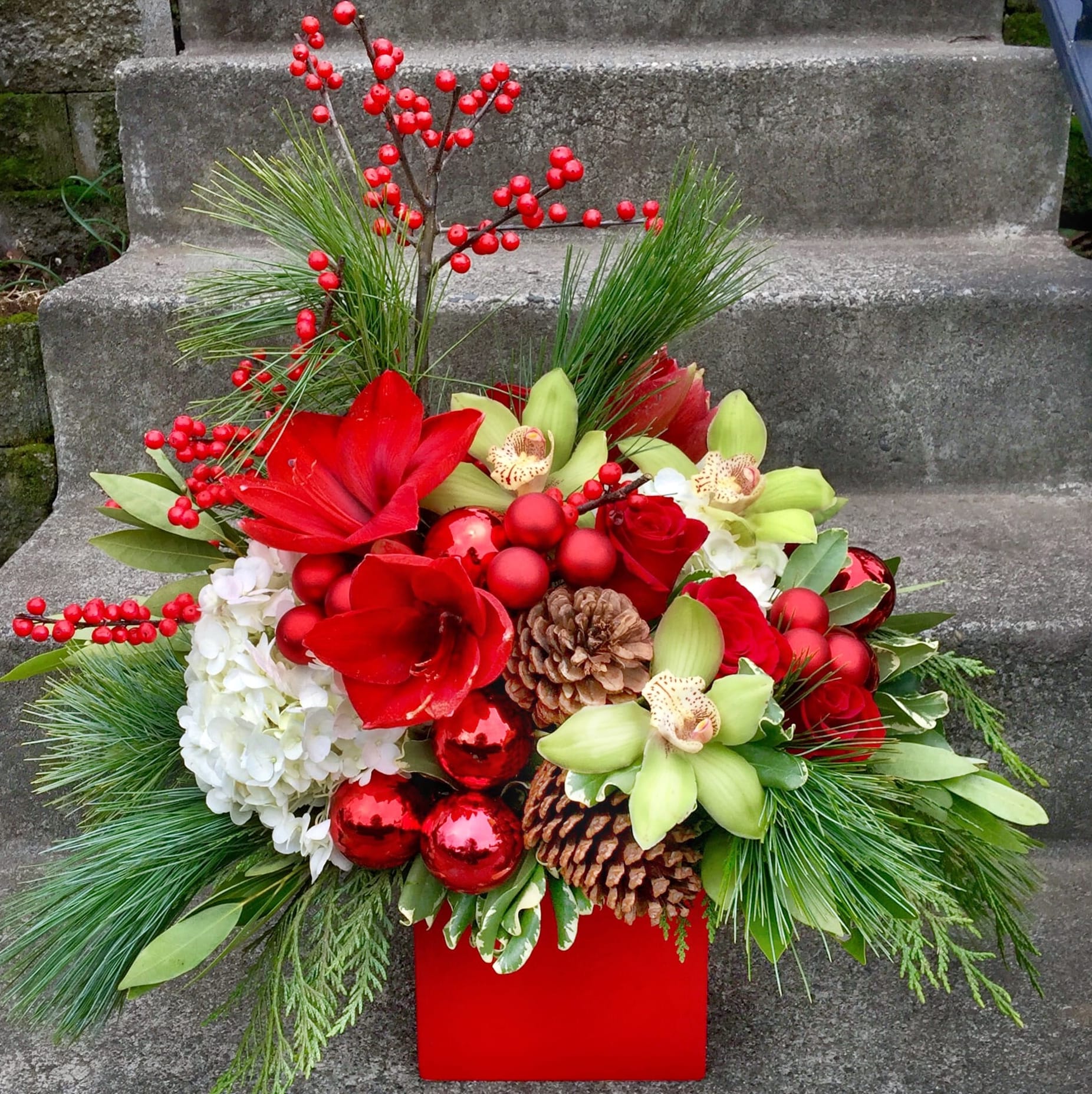 White Christmas - Available beginning December 3rd.  White Christmas is a holiday gift that is sure to impress. We go all out with this arrangement selecting flowers that you will not find in most traditional flower shops to create a floral that will let the recipient know just how much they mean to you. We even hand-write a special holiday note for you.   Approximate dimensions: 12 inches tall by 12 inches wide.   Orders for this Fiori Floral Design original arrangement to be delivered outside of our delivery area will be filled by a florist closer to the recipient. We will work closely to help them create something that has a similar feeling to our arrangement, but what they create may not match our photographs because every florist carries different items. They may need to substitute the vase, flowers used or greenery.