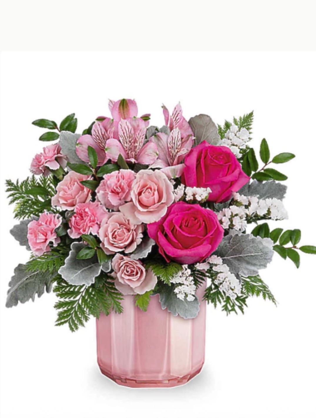 BLUSHING BOUQUET - Soft blush roses and rosy carnations mingle with pale alstroemeria and pops of purple filler to create a romantic, garden-style flower arrangement perfect for a birthday, anniversary, or a "just because" surprise. The Blushing Bouquet reads as fresh and gently playful-ideal for Mother's Day, Valentine's Day, or a Get Well sentiment-so the person you're thinking of will feel seen and cherished the moment it arrives.  Arranged with glossy decorative foliage and bright green berry accents, the bouquet comes in your choice of a clear square glass vase or a faceted pink glass vase for a clean, modern finish. The palette of pink, purple, green, and white is layered with texture: full roses, spray roses, dianthus and carnations for softness, striped alstroemeria for detail, and white filler to brighten the edges. The result is lush and feminine without feeling fussy. 