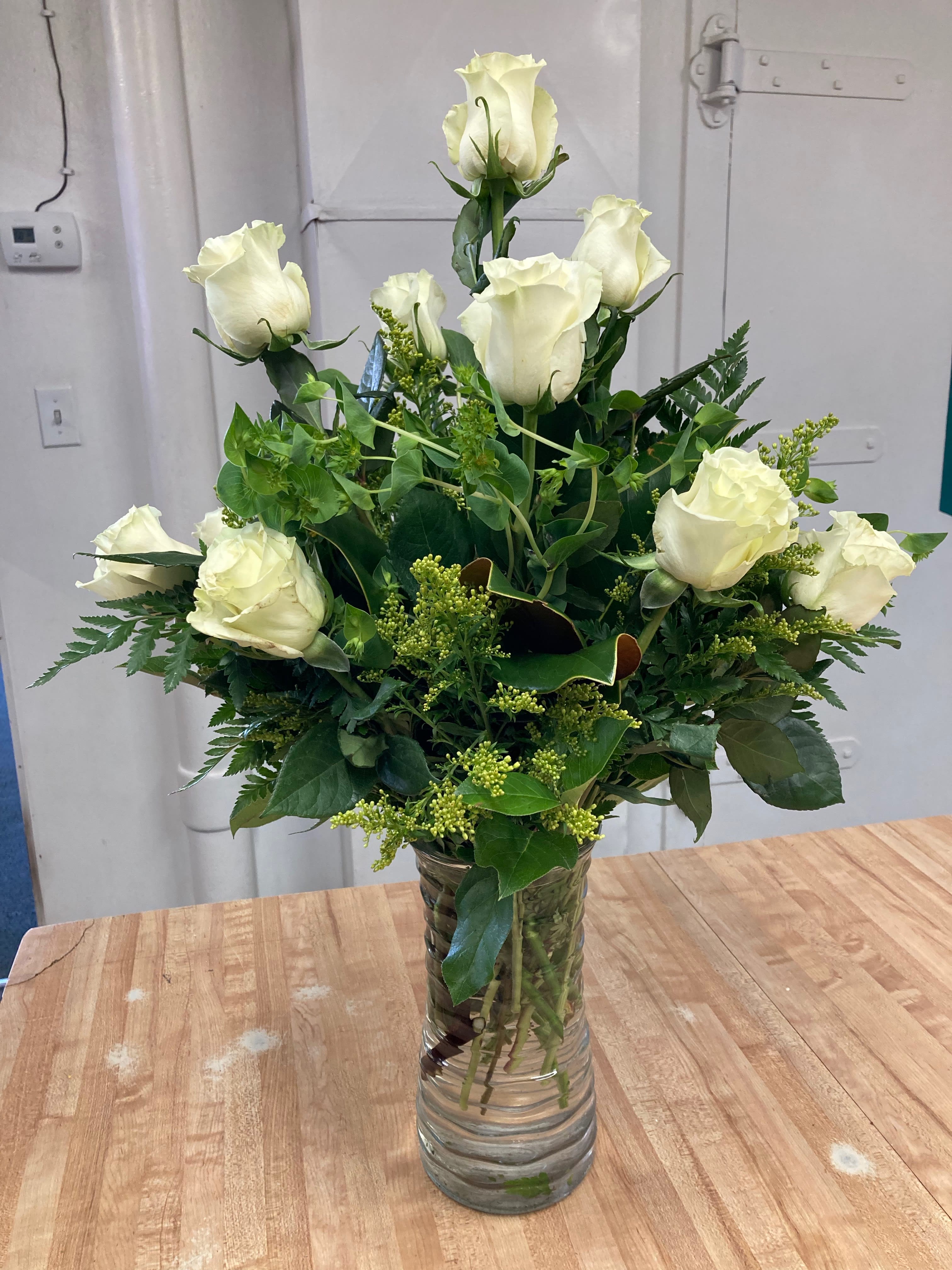 Half Dozen White Rose Bouquet - Six  fresh white roses arranged in a clear vase with filler and greenery. Roses are great for any and all occasions.