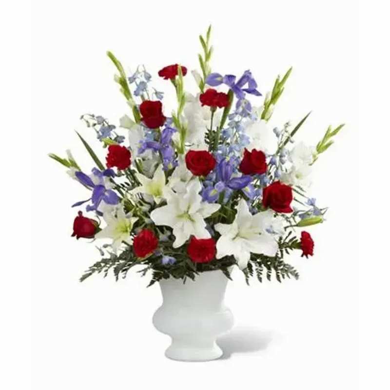  FTD® Cherished Farewell Arrangement™ - Red roses, red carnations, white gladiolus, light blue delphinium, blue iris, white Oriental lilies, white Asiatic lilies and lush greens are elegantly arranged in a white plastic urn to create a stunning way to say your last goodbye. 