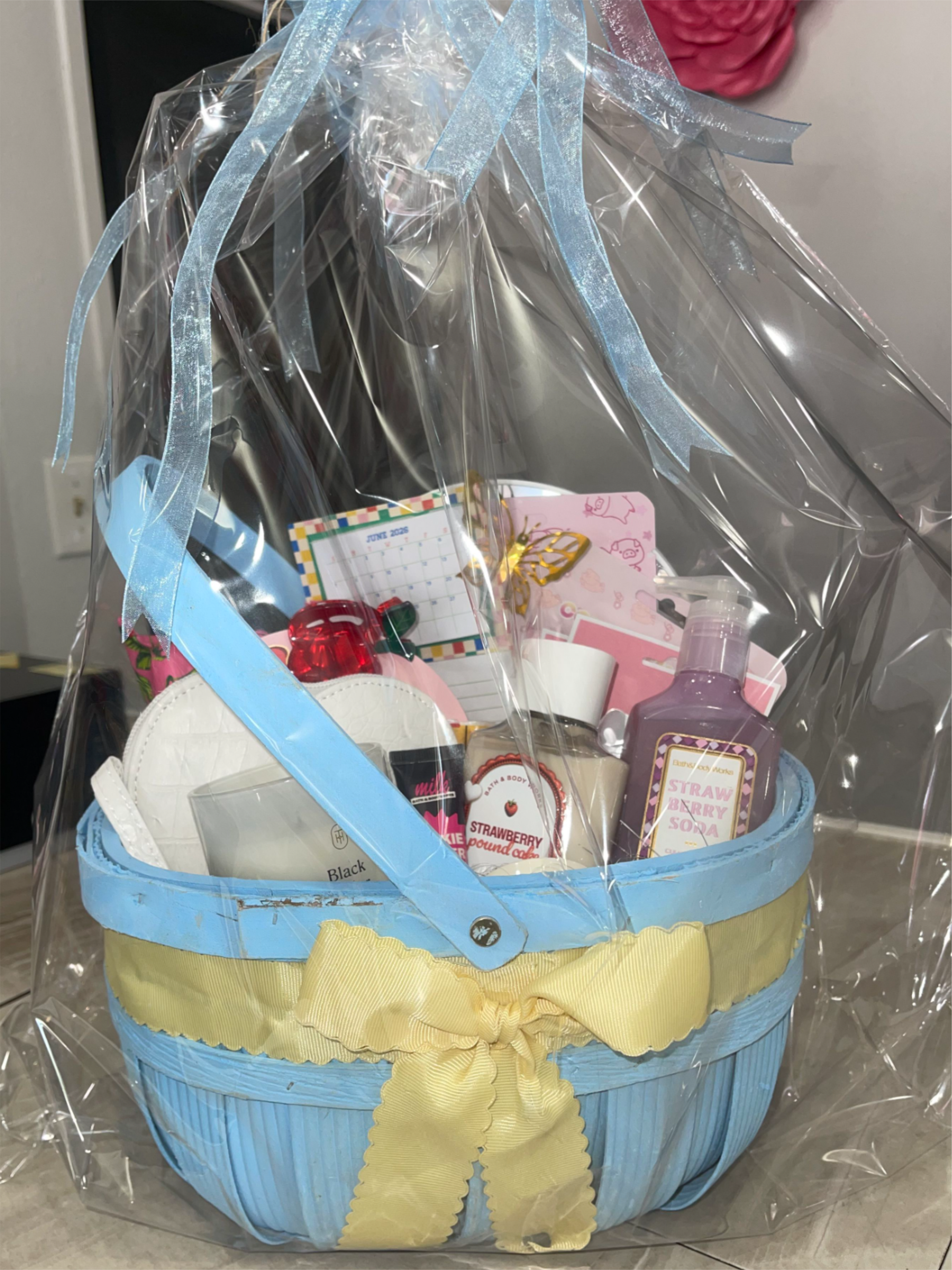 Gift basket with bath and body items wrapped in clear plastic and ribbon