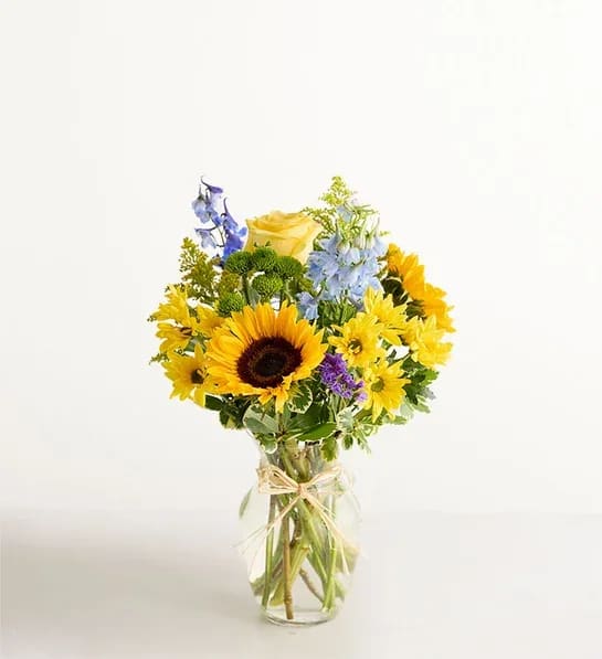 Fields Of Europe® Summer - Inspired by the colorful charm of the European countryside, our best-selling summer bouquet is gathered with fresh-picked blooms, revealing the rustic beauty of nature. Shades of golden yellow and rich blue pop against lush greenery, creating a timeless gift for someone special to enjoy. 