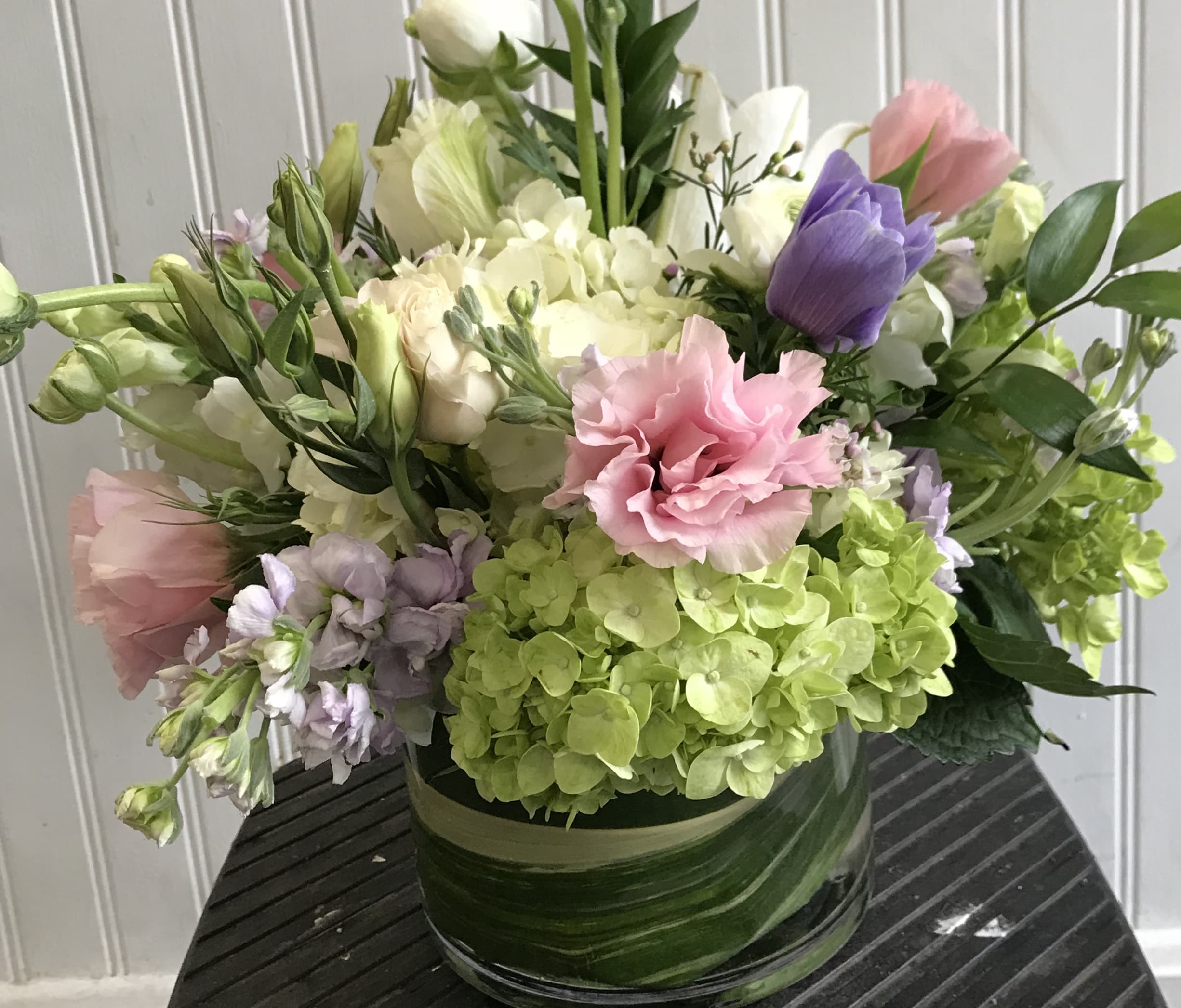 Mixed bouquet in a glass vase with pink, purple, white, and green blooms