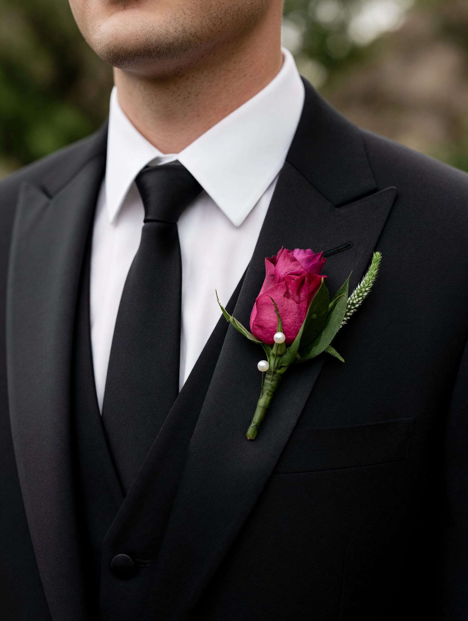  Purple Classic Boutonniere - A timeless purple boutonniere featuring a fresh bloom accented with complementary greenery. Carefully handcrafted for weddings, proms, and other special occasions, this elegant floral accent adds the perfect finishing touch to any suit or tuxedo.