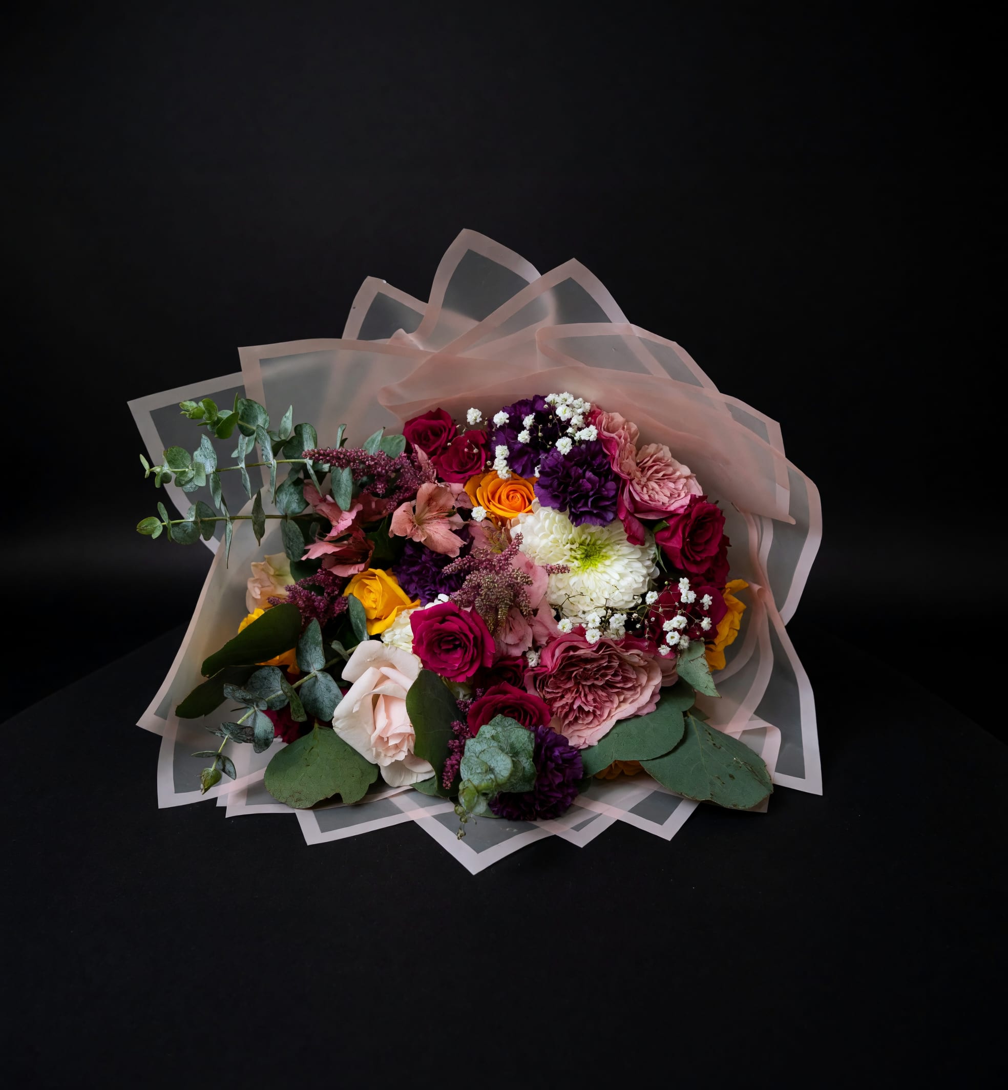 Wildflower Confetti - A vibrant hand-wrapped bouquet featuring roses, seasonal blooms, eucalyptus, and whimsical garden textures in a lush, colorful design full of movement and charm