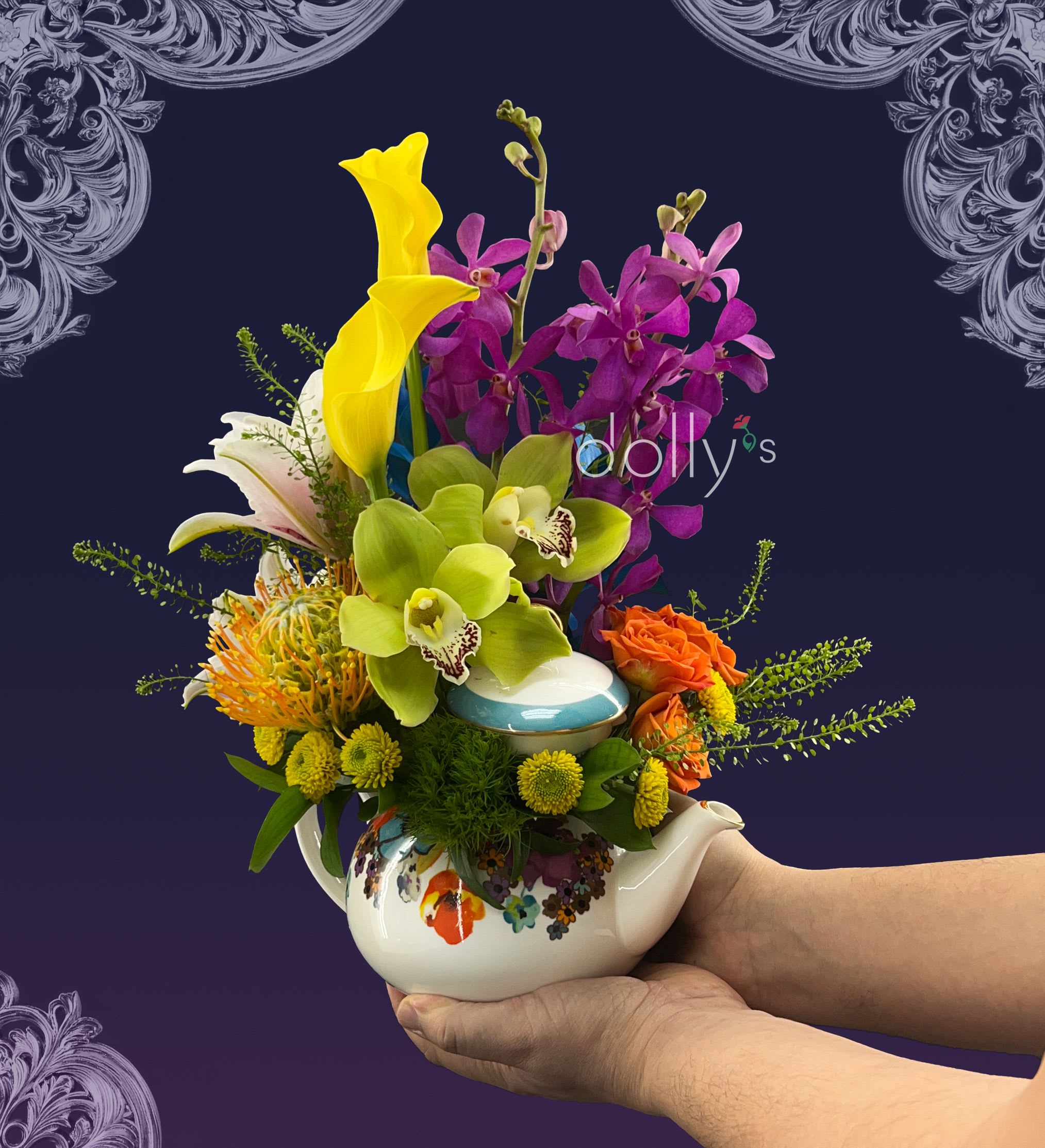 Colorful bouquet in a floral teapot with orchids, calla lilies, and roses