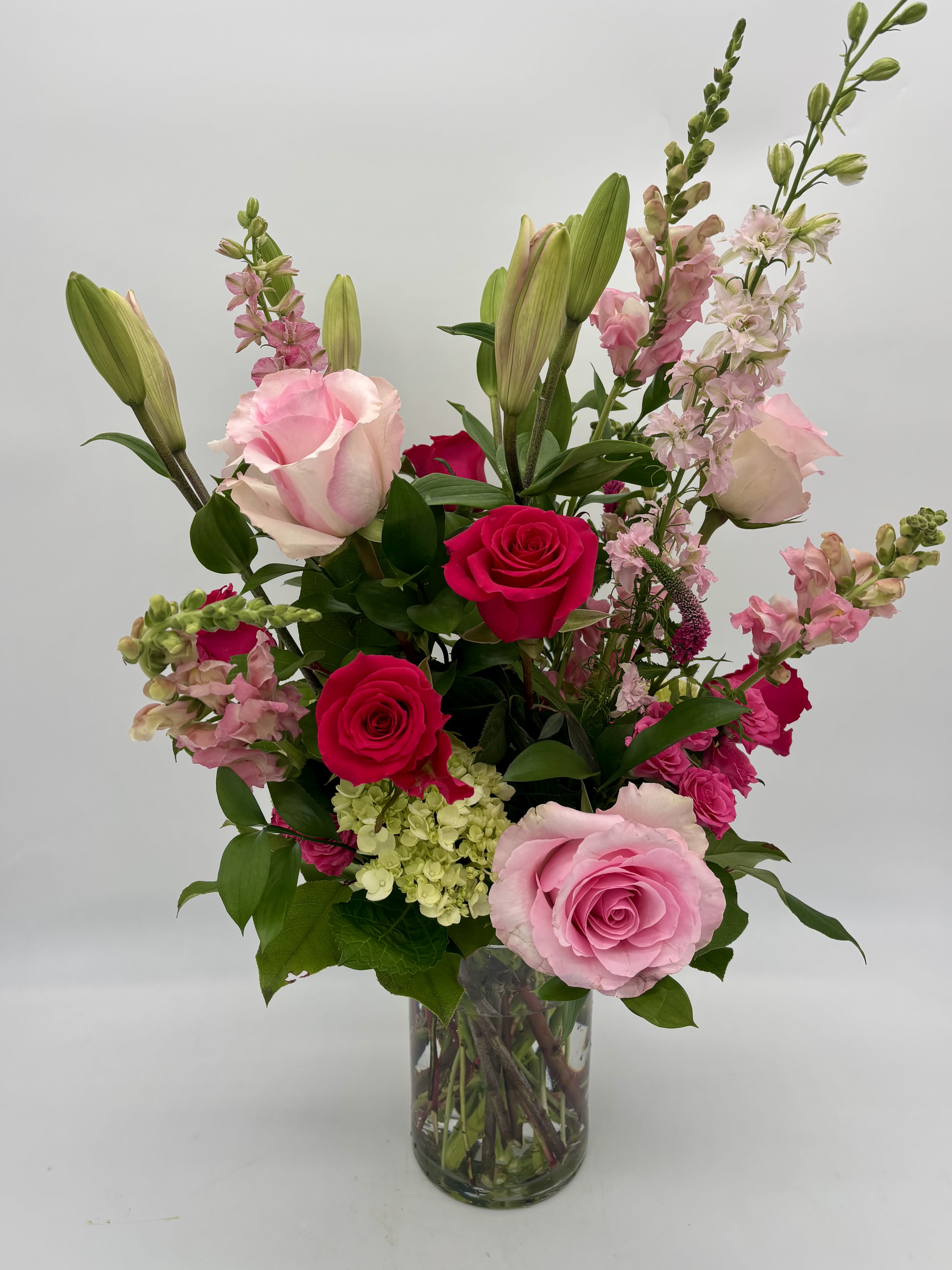 Fit for a Queen Luxury Bouquet - A luxurious gift fit for royalty, this bouquet is bursting with pink and green blooms and is sure to make an entrance.  Details The Deluxe Bouquet is approximately 21"H x 23"W. Designed by florists, ready to display. For long–lasting blooms, replace the water daily. We suggest trimming the stems every couple days. Pet Safety Precautions: This bouquet or plant may include flowers and foliage that are known to be toxic to pets. To keep them safe, be sure to keep this arrangement out of your pet's reach.  Bloom Details Rose Snapdragon Lily Hydrangea