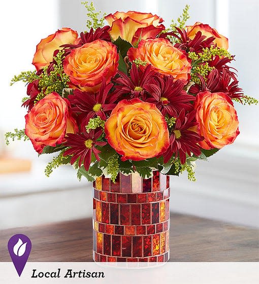 Amber Dreams - All-around arrangement with autumn-colored roses and red daisy poms; accented with solidago and assorted greenery. Arrangements are hand-designed so colors and varieties may be substituted with similar items based on local availability. 