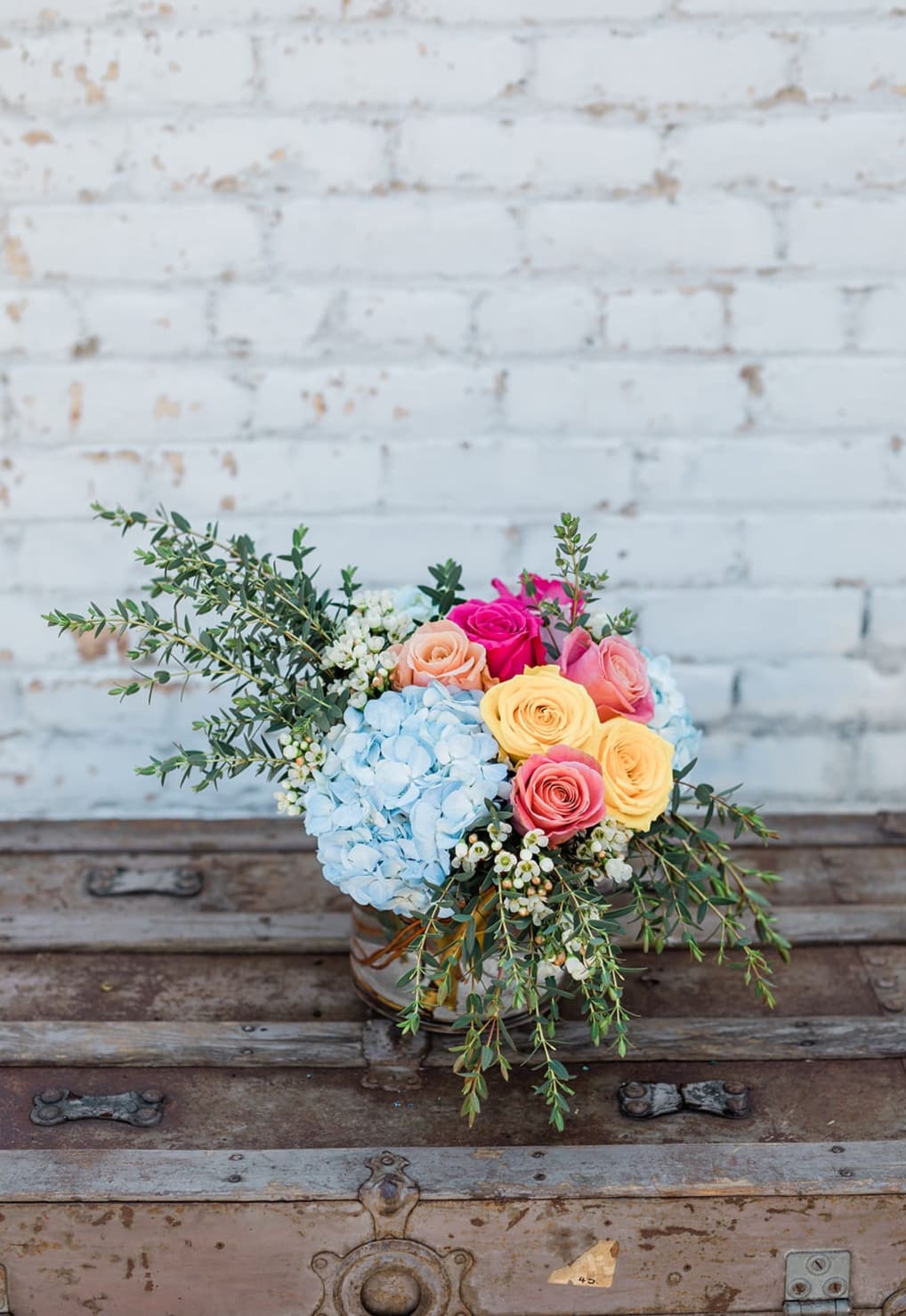 Bouquet of pastel roses and blue hydrangea in a glass vase