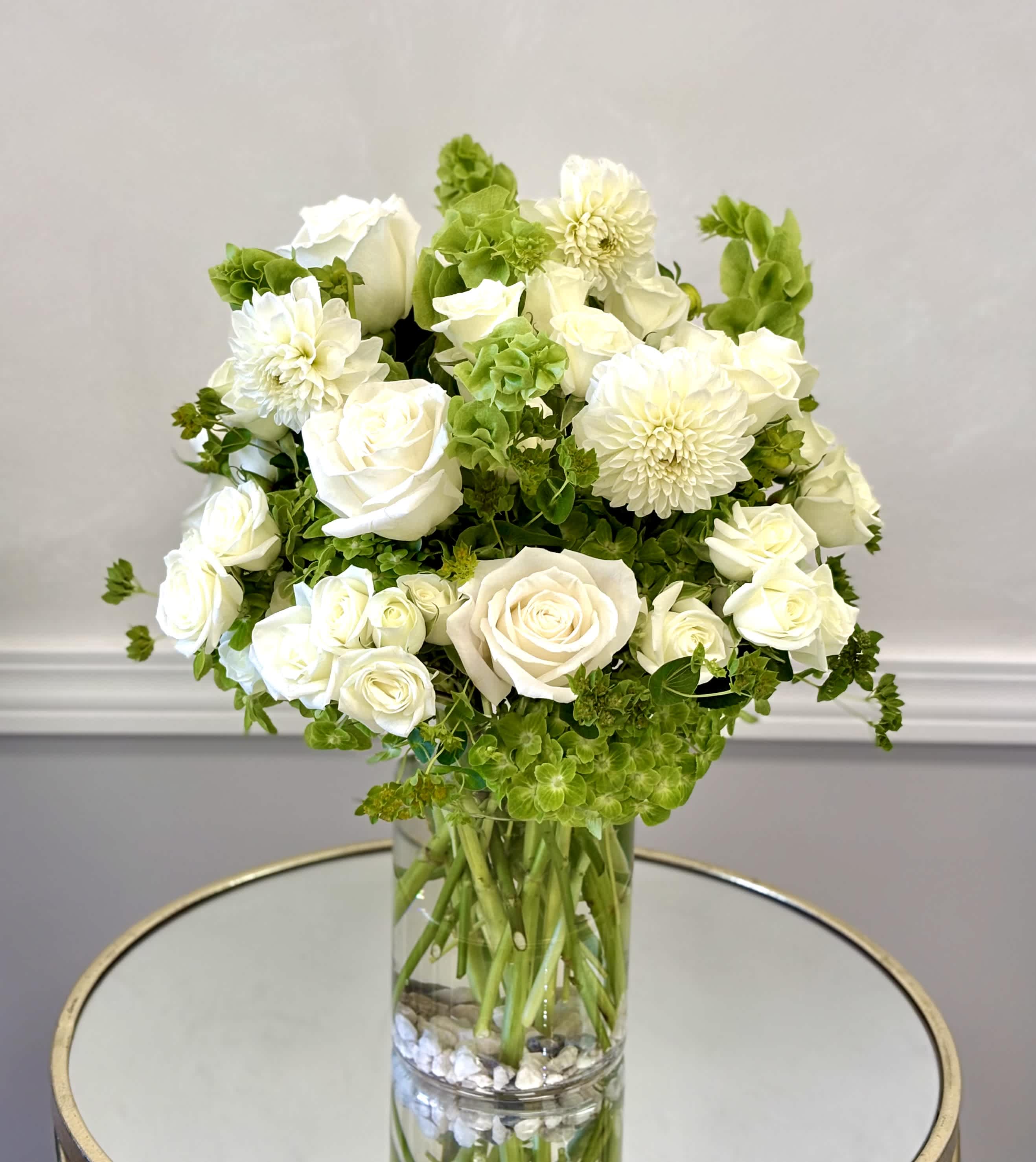 White roses and dahlias arranged in a clear glass vase