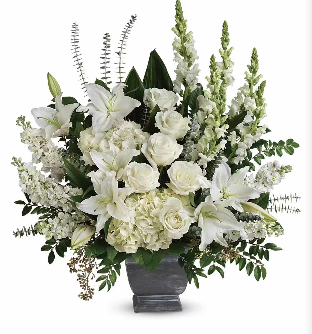 White lilies and roses arranged in a gray urn vase