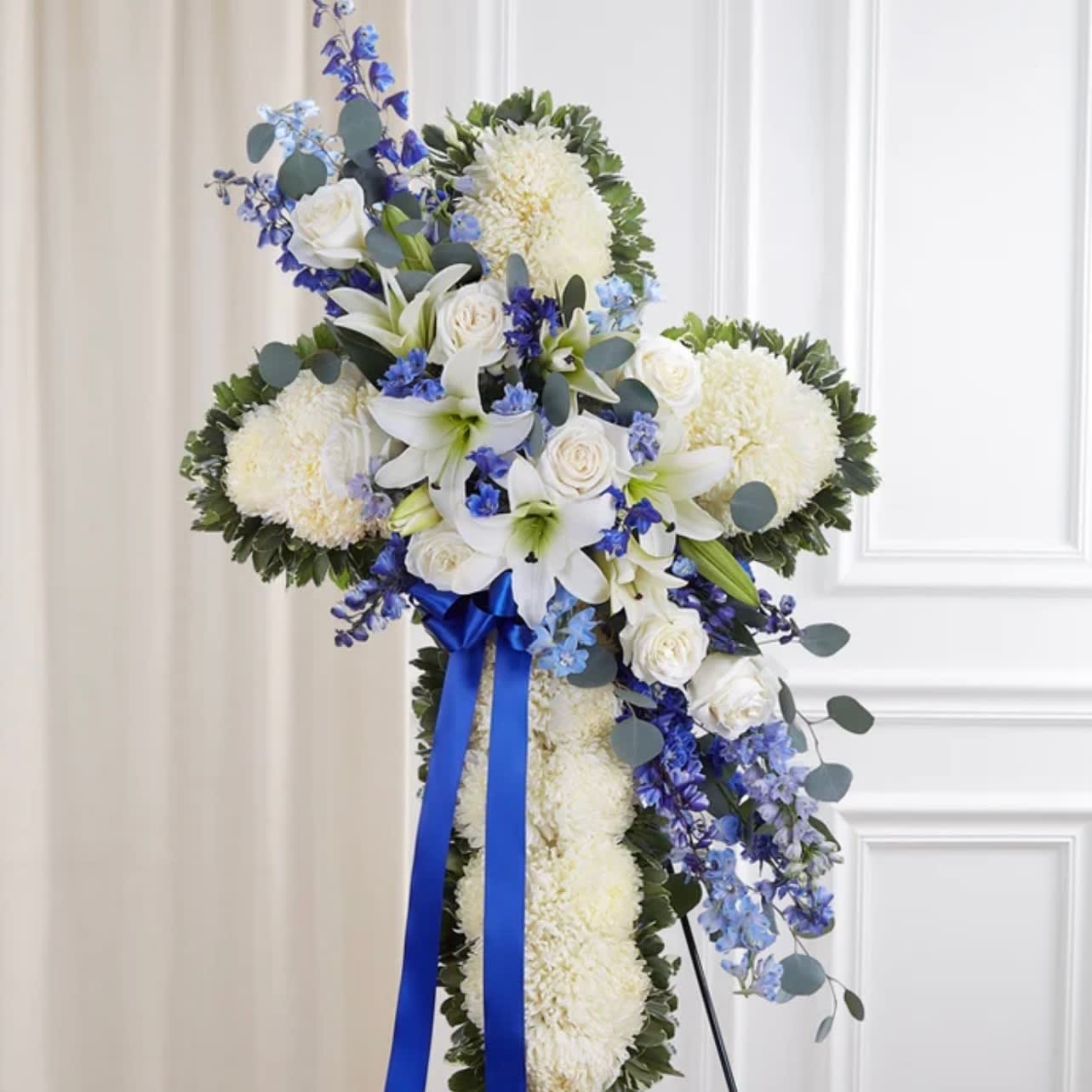 Blue and white Swag Cross  - Dark and light blue delphinium, white lilies, and white roses that create a beautiful swag across a white cross  