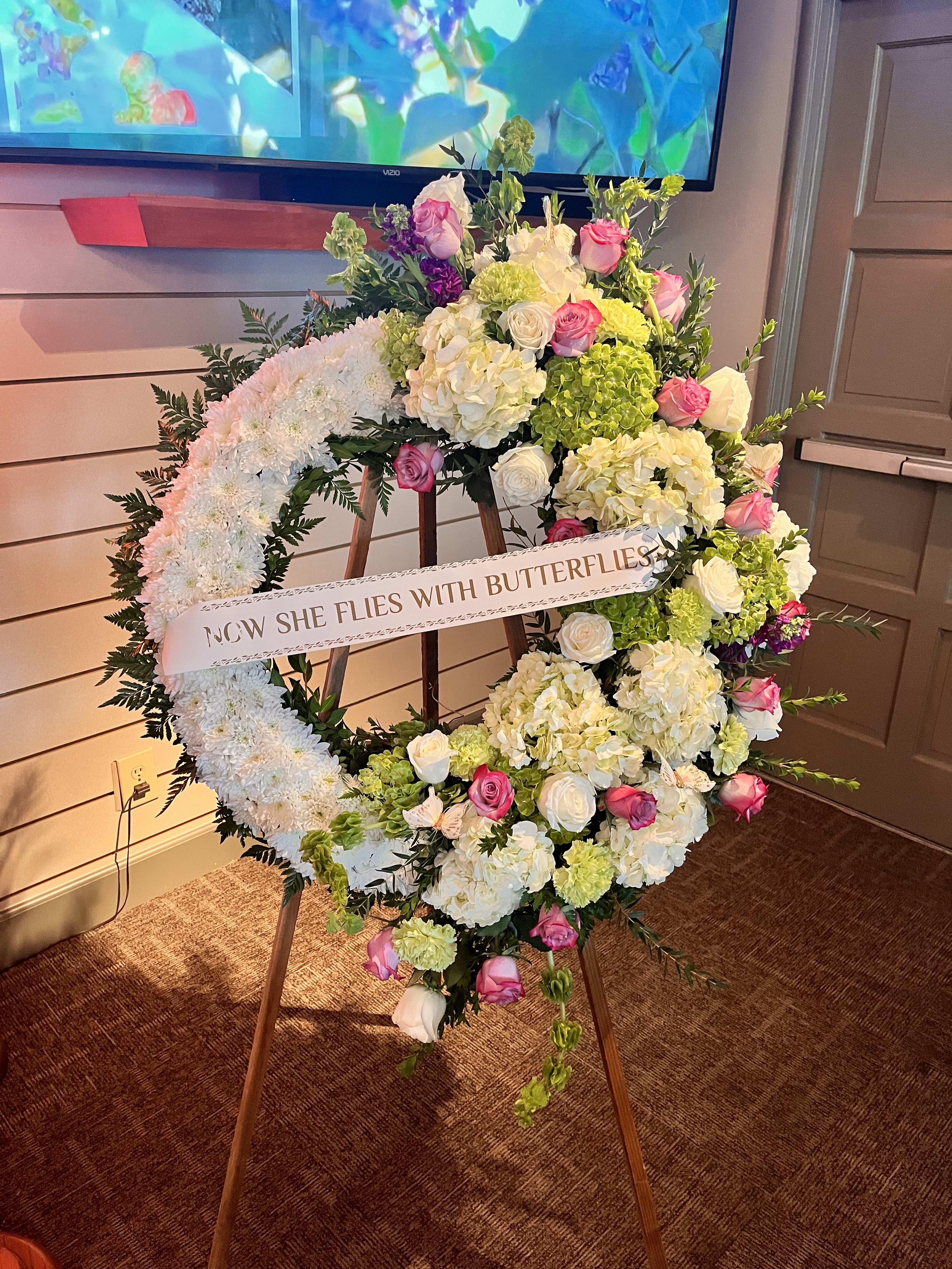 Butterfly wreath - A beautiful swag wreath containing hydrangeas, roses, stock, carnations, bells of ireland, and various greens.   