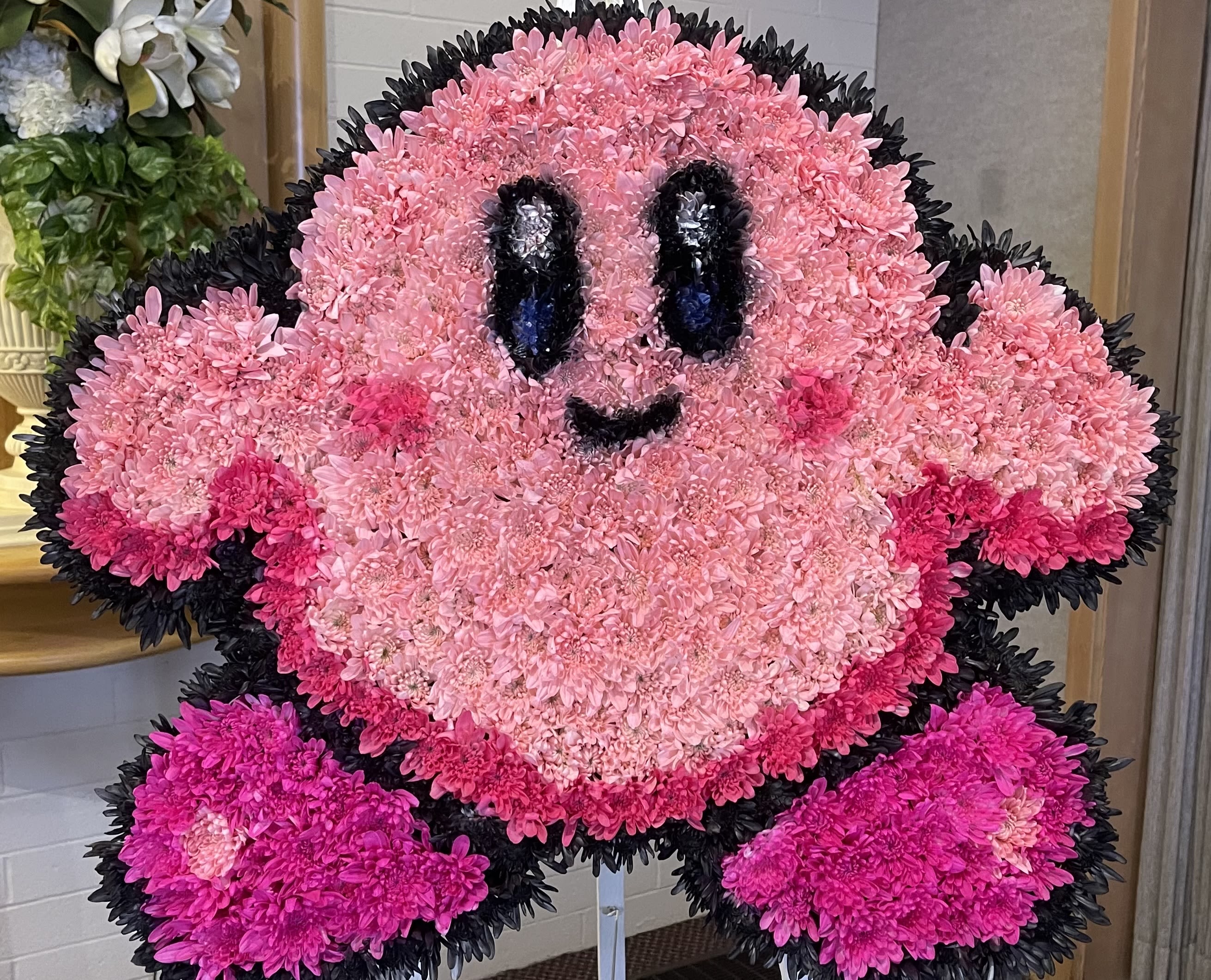 Pink floral character arrangement with a smiling face and black outline