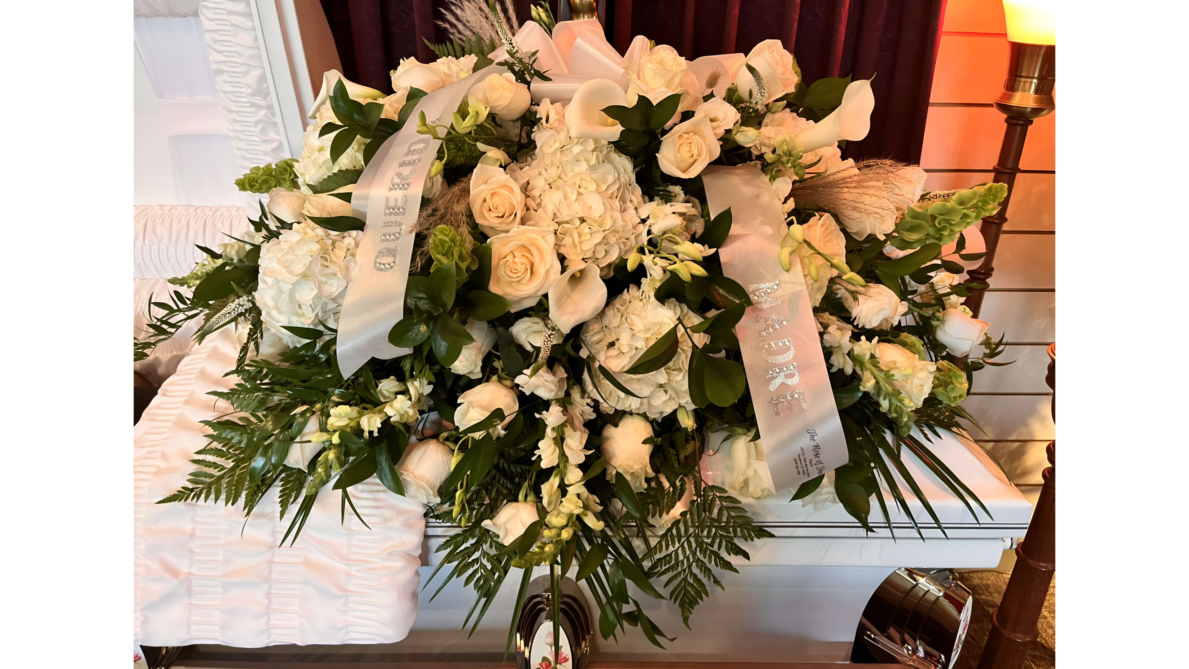 majestic casket  - An all white casket spray with different greens. 