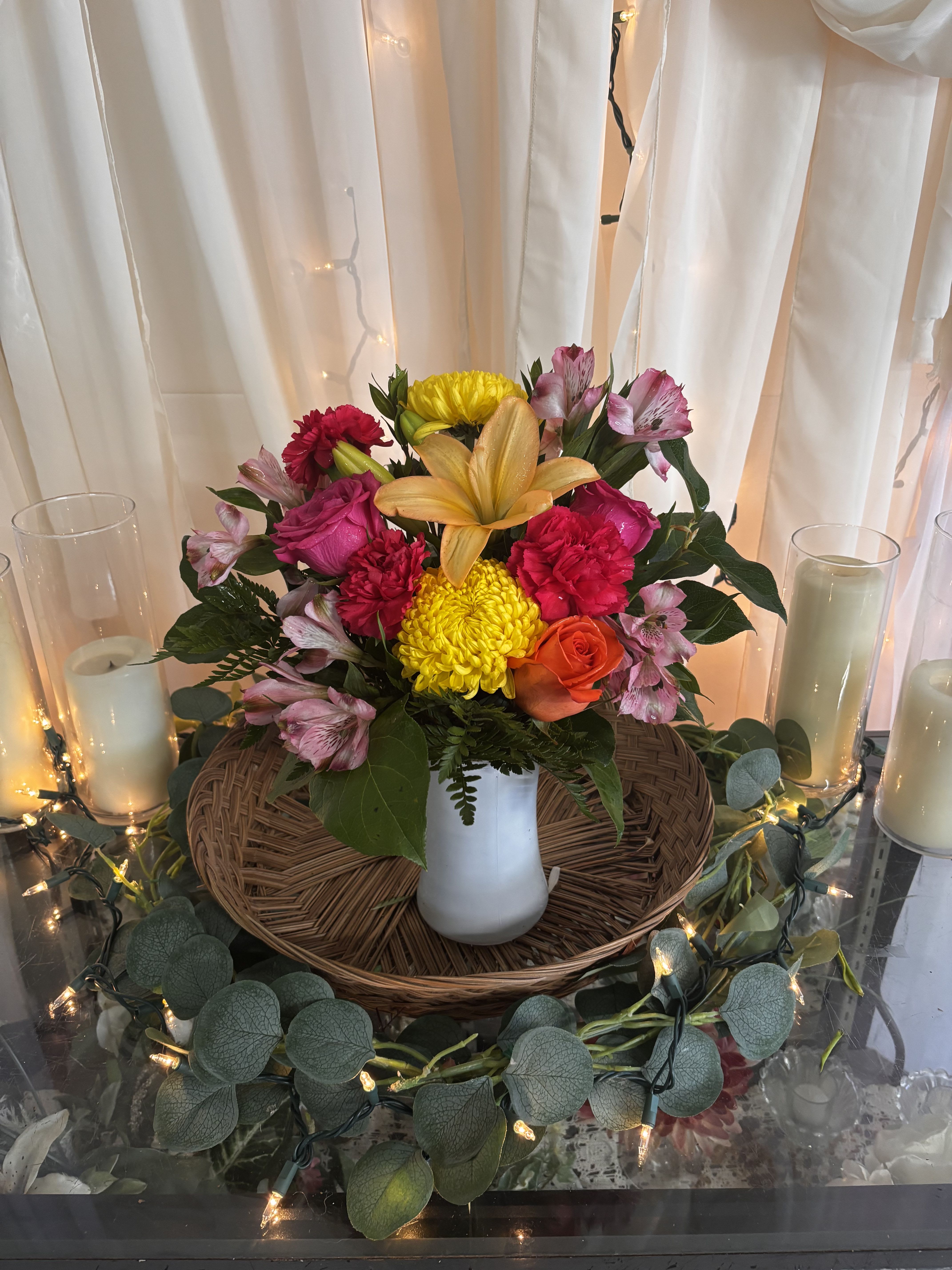 Storms - The flower arrangement features lilies, roses, carnations, chrysanthemums, and alstroemeria arranged densely in a smooth white ceramic vase so the person you're sending it to will feel truly celebrated by the color and texture on arrival.