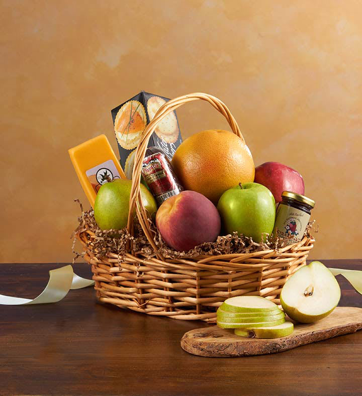 Fruit basket with apples, pears, citrus, and packaged snacks in a wicker basket