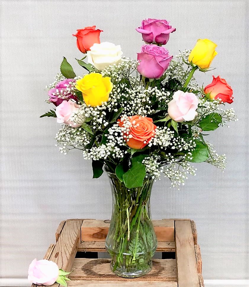 Mixed roses in a clear glass vase with baby's breath.