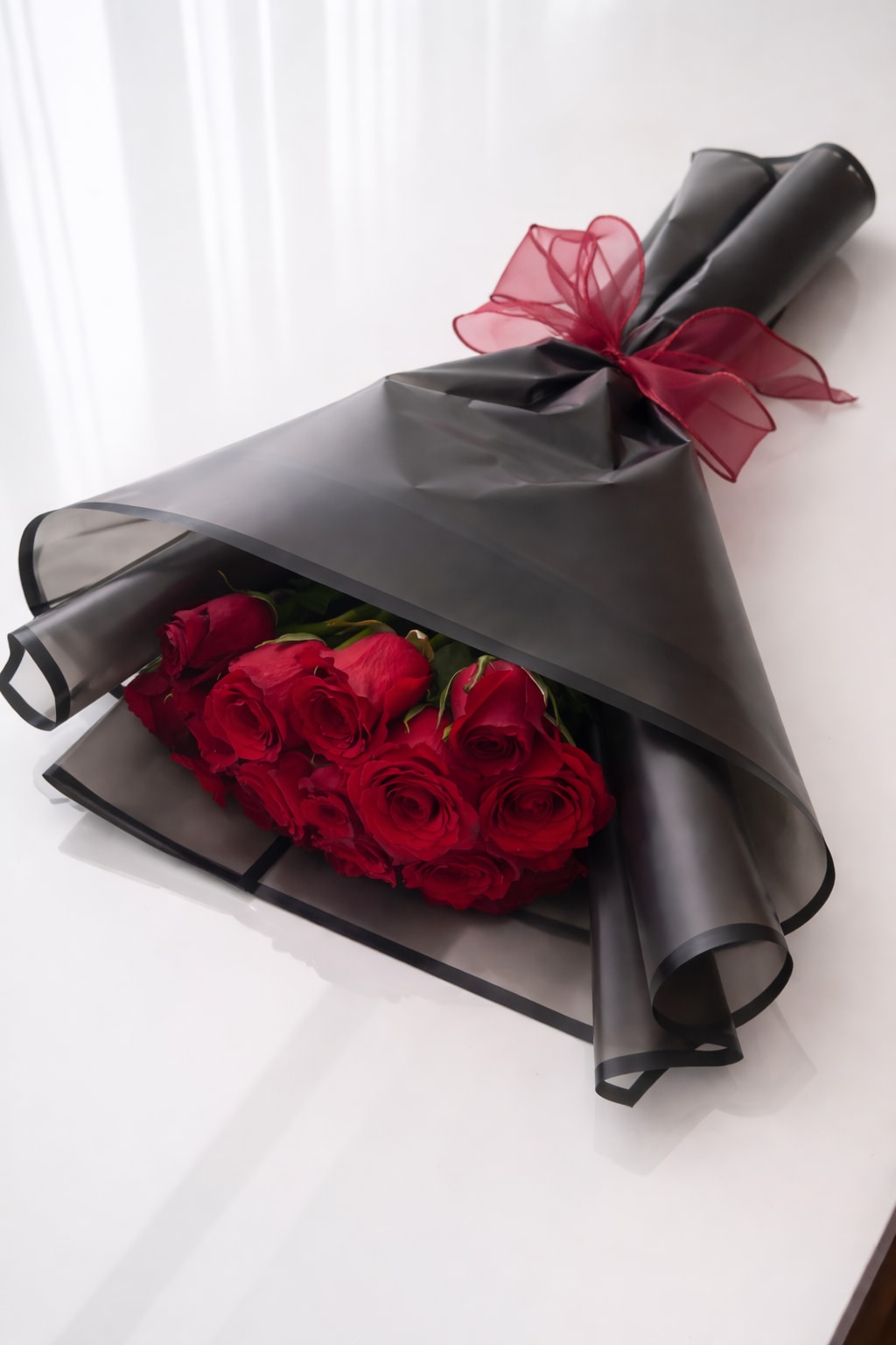 Classic Red Roses Bouquet - A stunning arrangement of 18 fresh red roses wrapped in elegant black paper and finished with a delicate ribbon. Perfect for romantic gestures, special occasions, or simply brightening someone’s day. Handcrafted with care, this bouquet delivers timeless beauty and sophistication in every detail