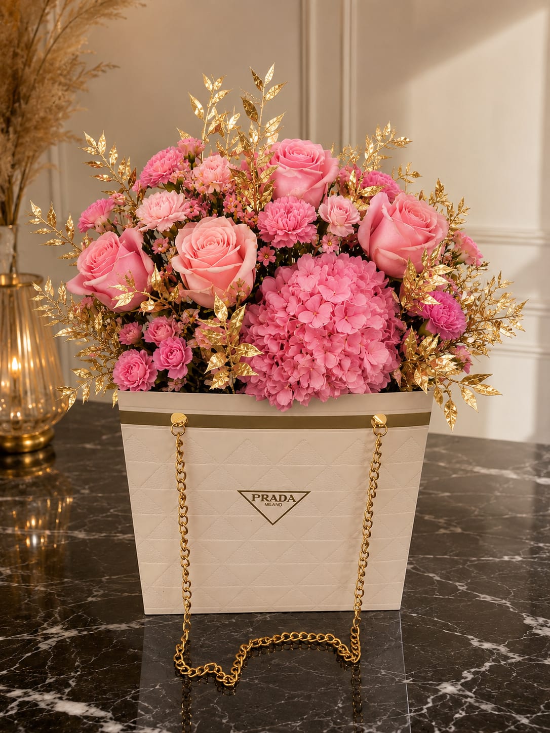 Pink Radiance - Soft pink roses and a plush dome of pink hydrangeas create a romantic, fashion-forward birthday bouquet perfect for anniversaries or a stylish just-because gift. The arrangement's pink, white, and yellow palette reads feminine and celebratory-made to make the person you're thinking of feel cherished and noticed the moment it arrives.  Large pink roses anchor the design, surrounded by rounded pink hydrangea clusters and smaller pink carnations and blooms for texture and depth. Metallic gold foliage is woven through the flowers for a reflective, polished contrast, and subtle white and yellow accents brighten the composition. Everything is presented in a cream-colored gift bag with gold chain handles and a branded logo, giving the piece a luxe, ready-to-gift finish.  This is the kind of arrangement that elevates milestone moments or turns an ordinary day into something memorable; it's ideal for birthdays, anniversaries, or when you want to celebrate someone with style. Size and care: arranged in the bag for immediate display-keep flowers in a cool spot away from direct sun and refresh water if stems are in a water source; order early for special-date delivery.