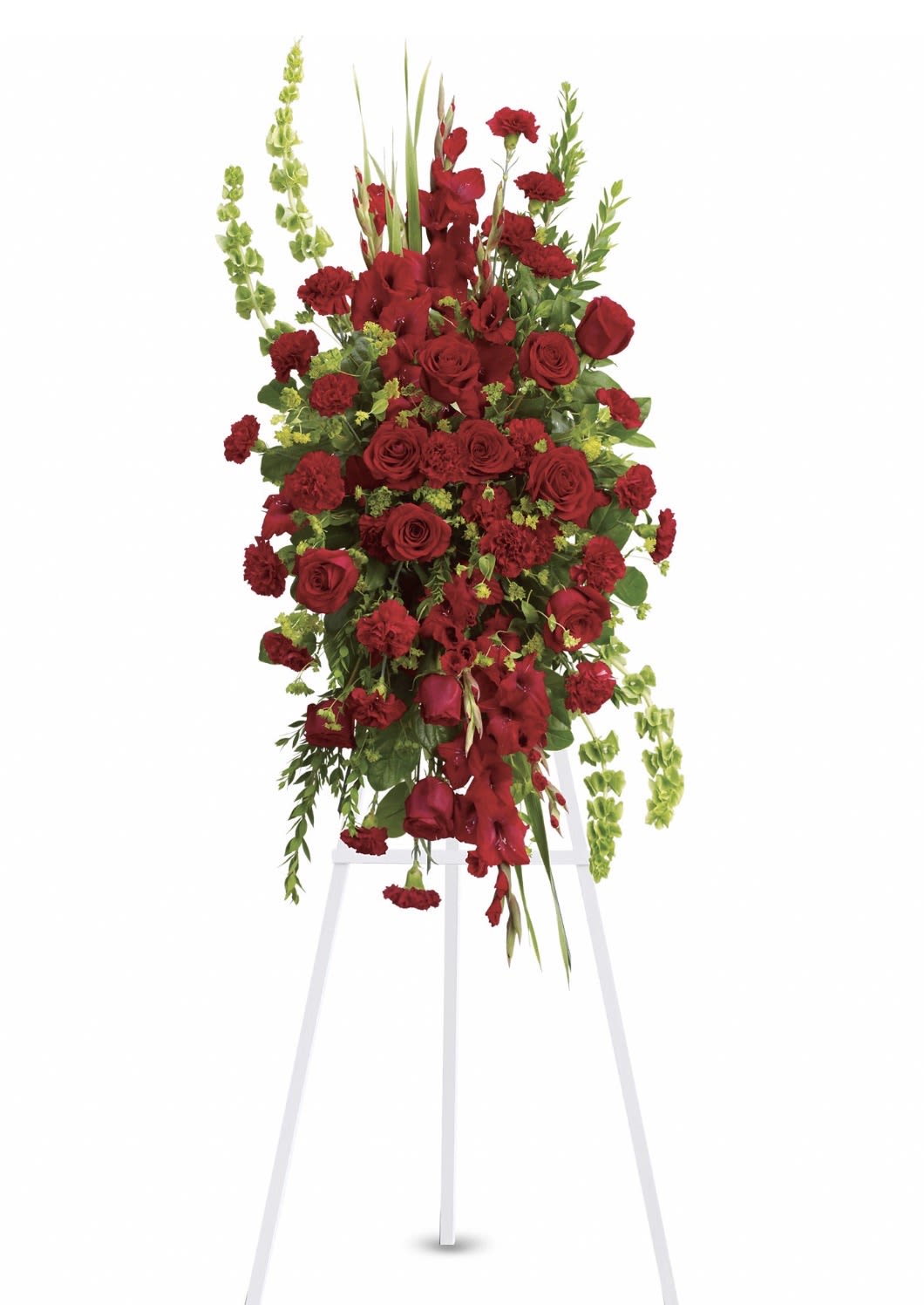 Care and Compassion Spray - A dramatic cascade of deep red roses and carnations creates a solemn, elegant statement-perfect as a sympathy and funeral standing spray. This formal funeral arrangement places the focus on rich red blooms arranged in a dense, upright mass so the person you're honoring reads as dignified and deeply remembered. The white easel lifts the piece for ceremony, giving it the presence appropriate for a memorial service or graveside tribute.  Accents of lighter green foliage and a few upright blooms add vertical movement and soften the composition, while trailing greens provide gentle contrast against the red. Designed to be seen from the front, the spray presents a refined silhouette that complements traditional service settings without feeling ornate. The scale and construction make it a ceremonial display rather than a handheld tribute, conveying care and compassion for the bereaved.