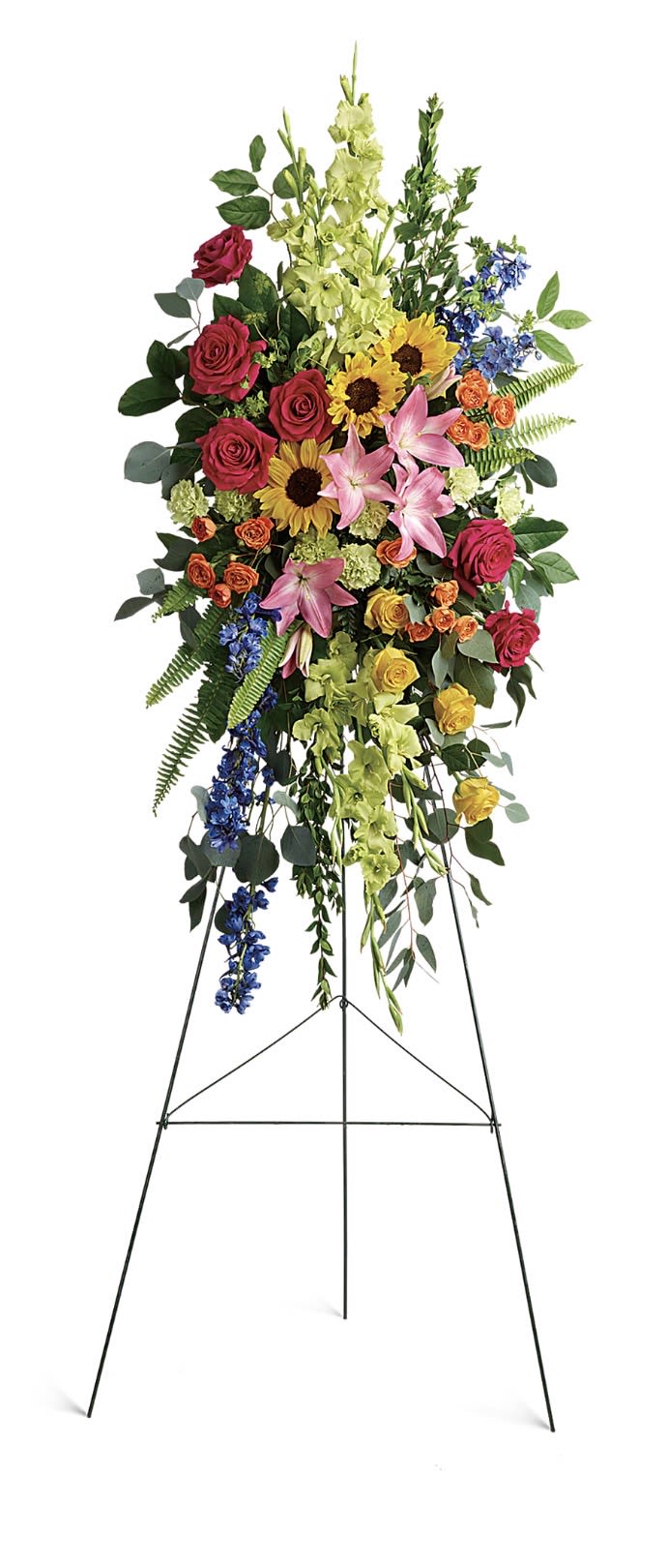 Love Lives On Spray - A tall standing spray that brings bold color and uplifting energy to a sympathy or funeral service, designed to honor a life with warmth and vibrancy. The Love Lives On spray features a layered, cascading composition built for vertical impact-an arrangement that reads as both respectful and celebratory, making it a meaningful tribute for memorials or remembrance ceremonies.  This mixed-color arrangement pairs red and pink roses with bright yellow sunflowers, pink lilies, alstroemeria, delphinium accents, spray roses, and pale green vertical spikes for texture. The strong vertical movement and trailing elements create a dramatic silhouette that draws the eye, while the varied blooms deliver contrast in shape and tone-soft lilies, bold sunflowers, ruffled alstroemeria, and delicate spray roses-so the display reads beautifully from a distance.  Made to stand proudly on the included metal easel stand, this spray is sized for ceremonial spaces and will give the person you're honoring a vivid, uplifting focal point. Designed for use at services year-round, it requires only routine care from the florist-no special instructions needed-so it arrives ready to convey your sympathy and celebration of a life lived.