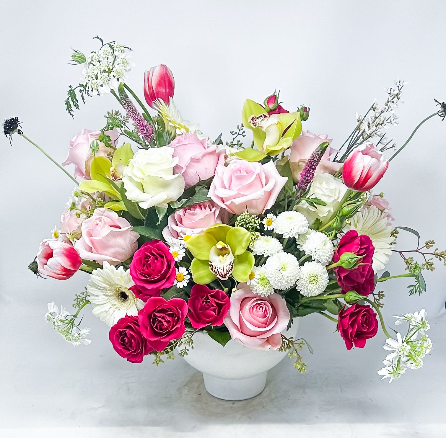Mixed bouquet of pink and white flowers in a white vase