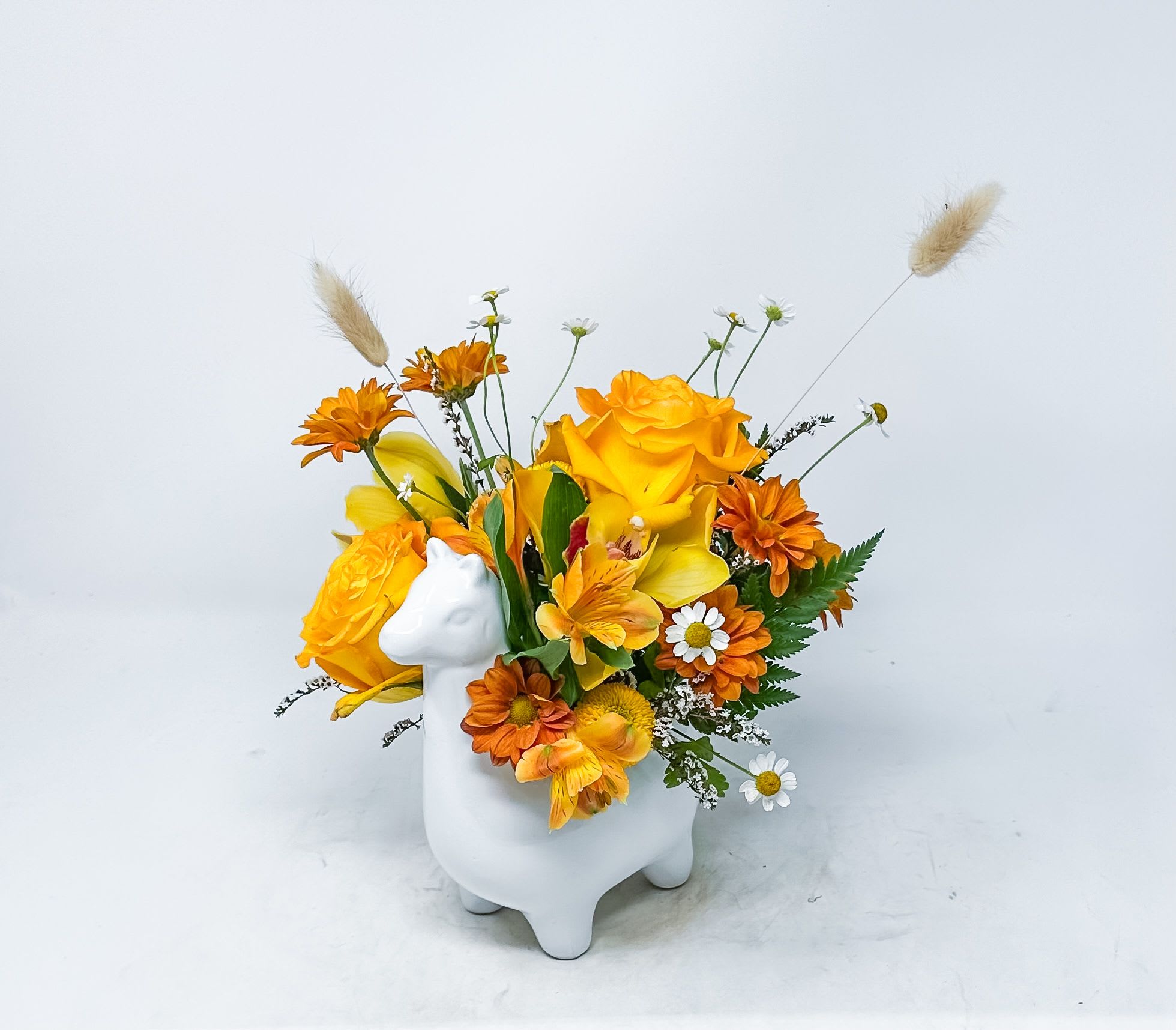 Orange and yellow flower arrangement in a white animal-shaped vase