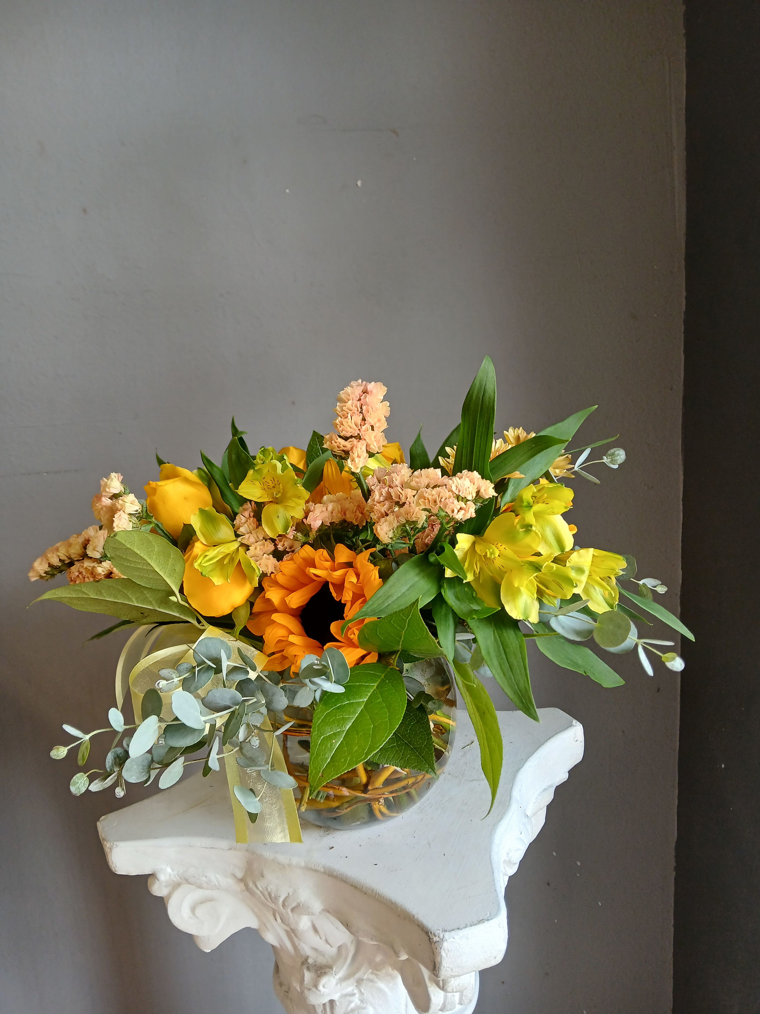 #704 Designer's Choice  -  Arranged in a clear glass vase, the bouquet is full and layered with clustered blossoms across the top and greenery and gentle trailing stems that soften the silhouette. Textures range from velvety rose petals to the crisp daisy centers and tubular snapdragon accents, creating visual depth and a fresh, romantic mood. Ideal for sending cheer or appreciation, this everyday vase arrangement arrives ready to display; change the water every few days and trim stems for longer-lasting blooms.