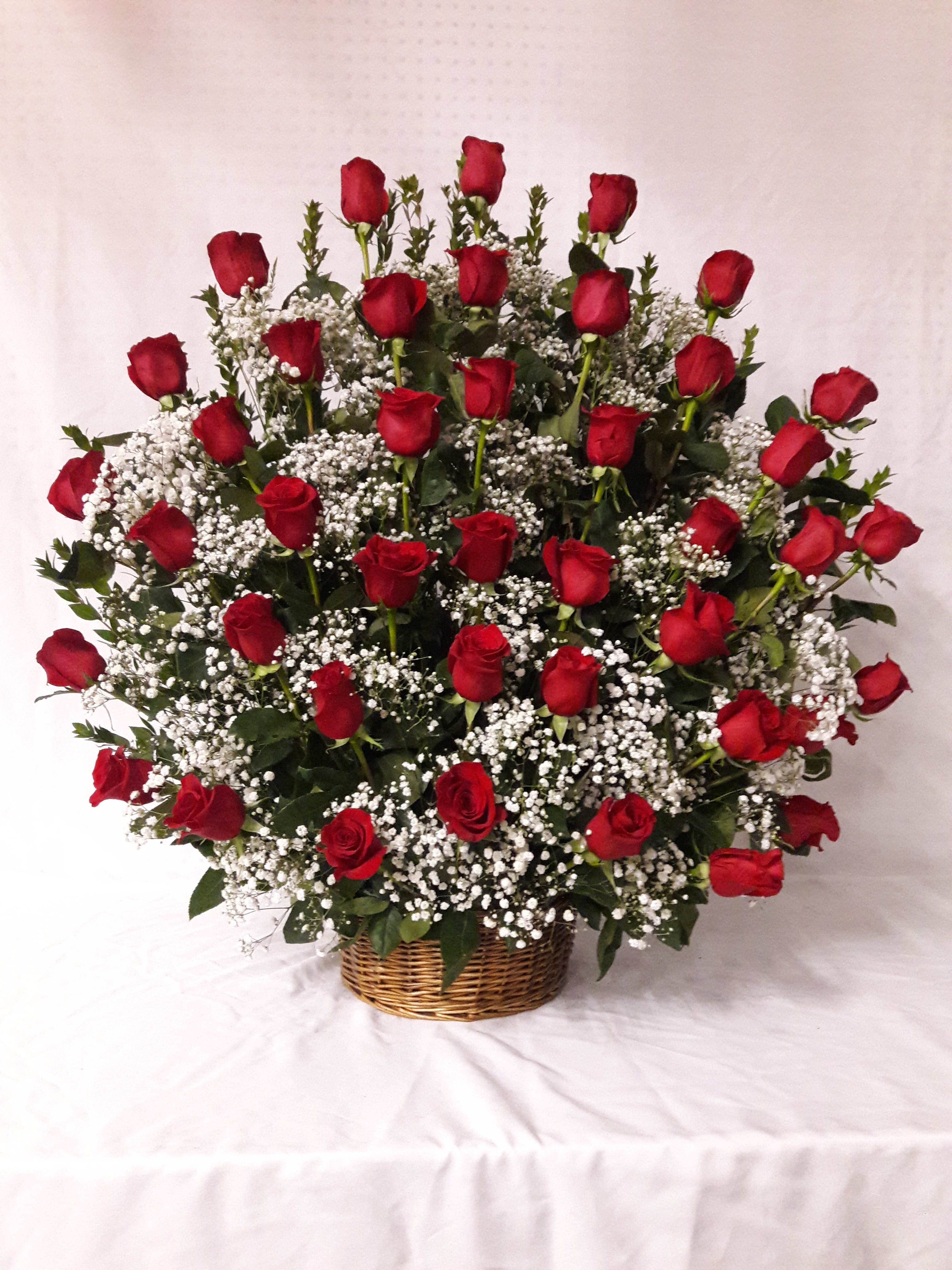 Basket arrangement of red roses with white baby's breath
