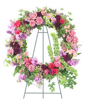 Large floral wreath on a metal easel with pink and purple flowers