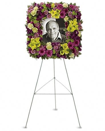 Mosaic of Memories Square Easel Wreath - A unique and lovely tribute for the service, this contemporary square easel wreath of purple and green flowers is a gift of caring expressed with beauty and style. The elegant arrangement includes purple alstroemeria, green gladioli, green carnations, purple cushion spray chrysanthemums, lavender button spray chrysanthemums, green button spray chrysanthemums and purple button spray chrysanthemums, accented with assorted greenery. 