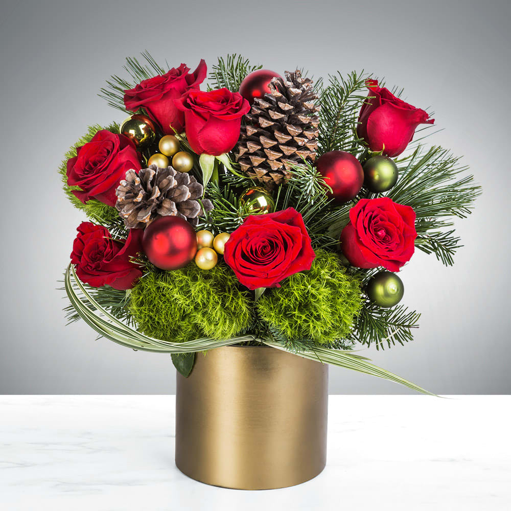 Red roses with pinecones and ornaments in a gold vase