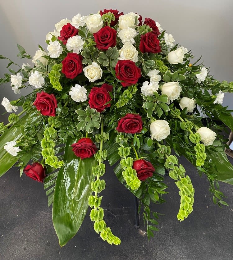 Large red and white rose arrangement with cascading greenery