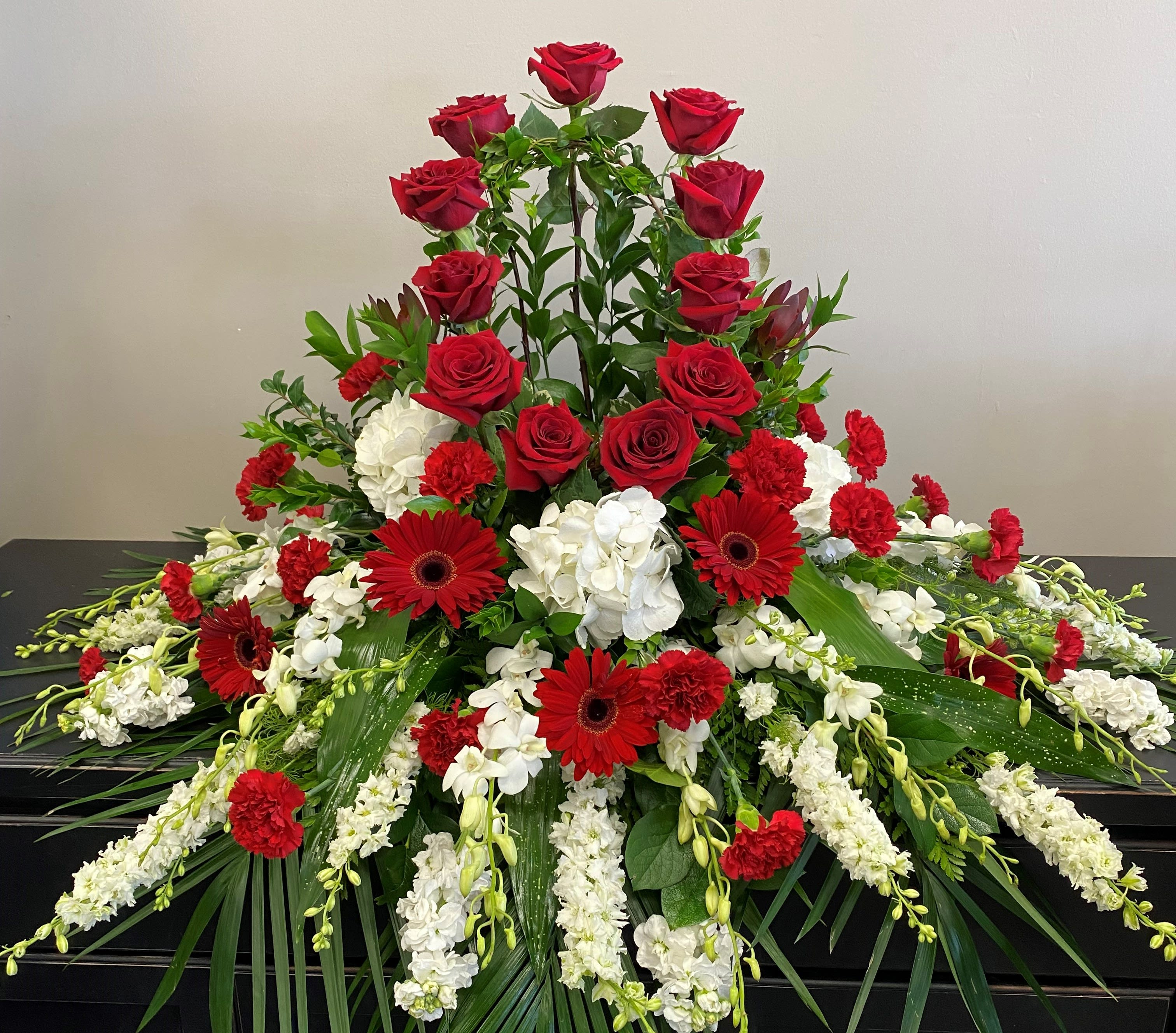 Large red and white floral funeral spray with roses and gerberas