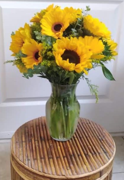 Yellow sunflowers arranged in a clear glass vase