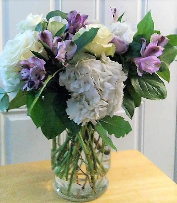 Bouquet of white and purple flowers in a clear glass vase