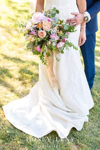 Bride holding a pastel bouquet with peach and pink roses