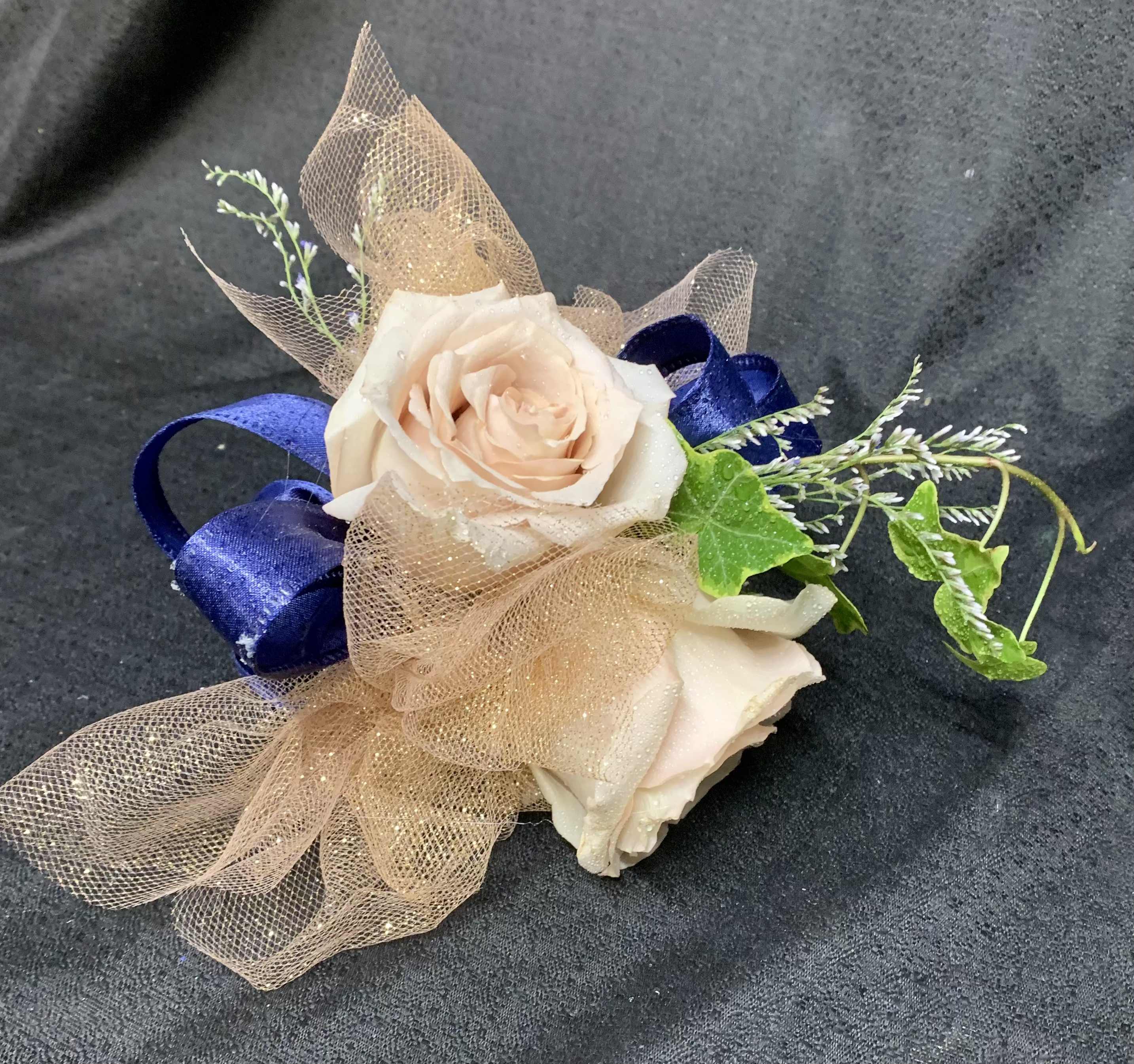 Two pale roses with blue ribbon and tan mesh wrap