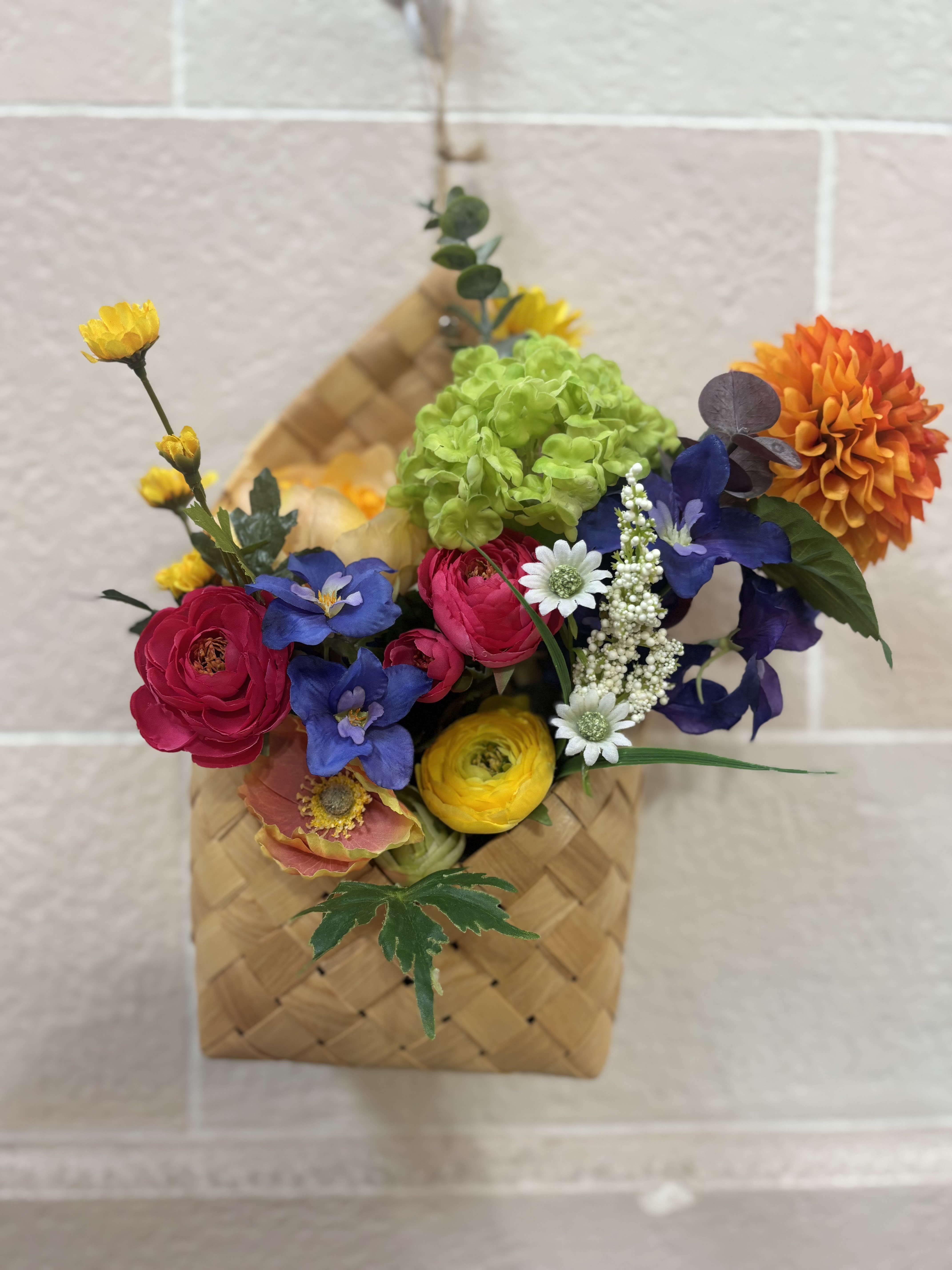 Colorful mixed bouquet in a woven basket with bright blooms