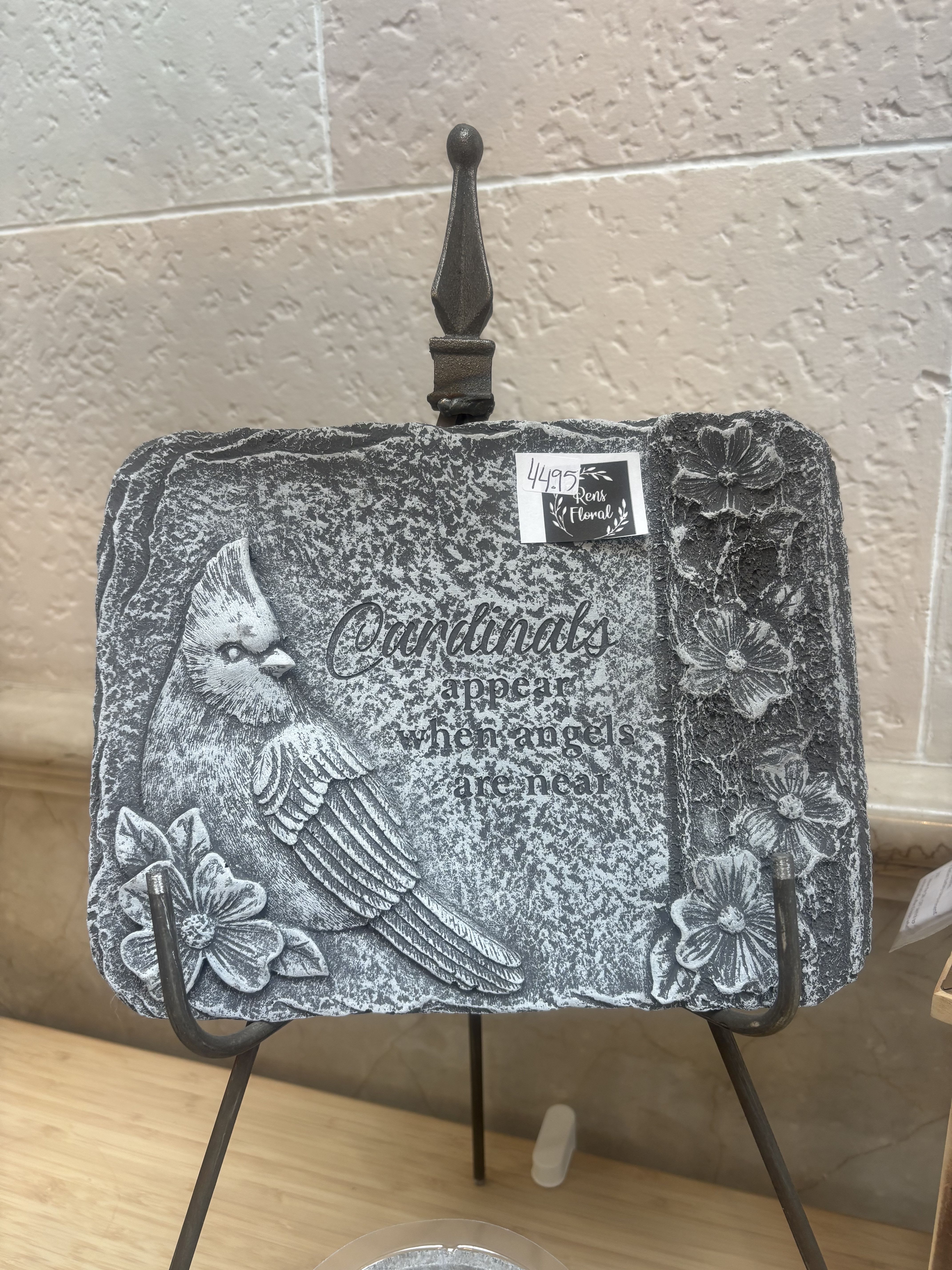 Decorative stone plaque with a cardinal and floral relief on a display stand