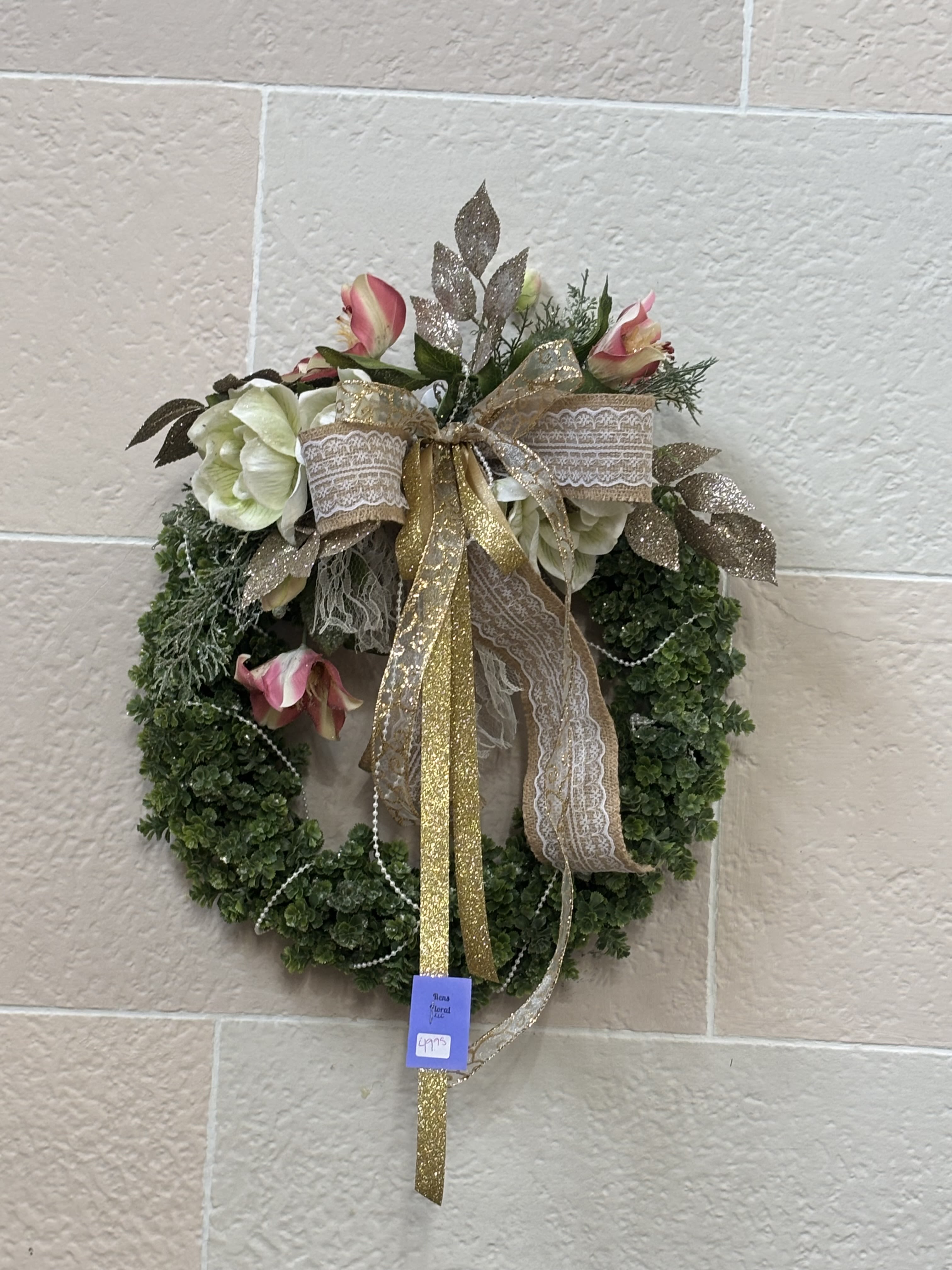 Floral wreath with pink and white flowers and a gold ribbon bow