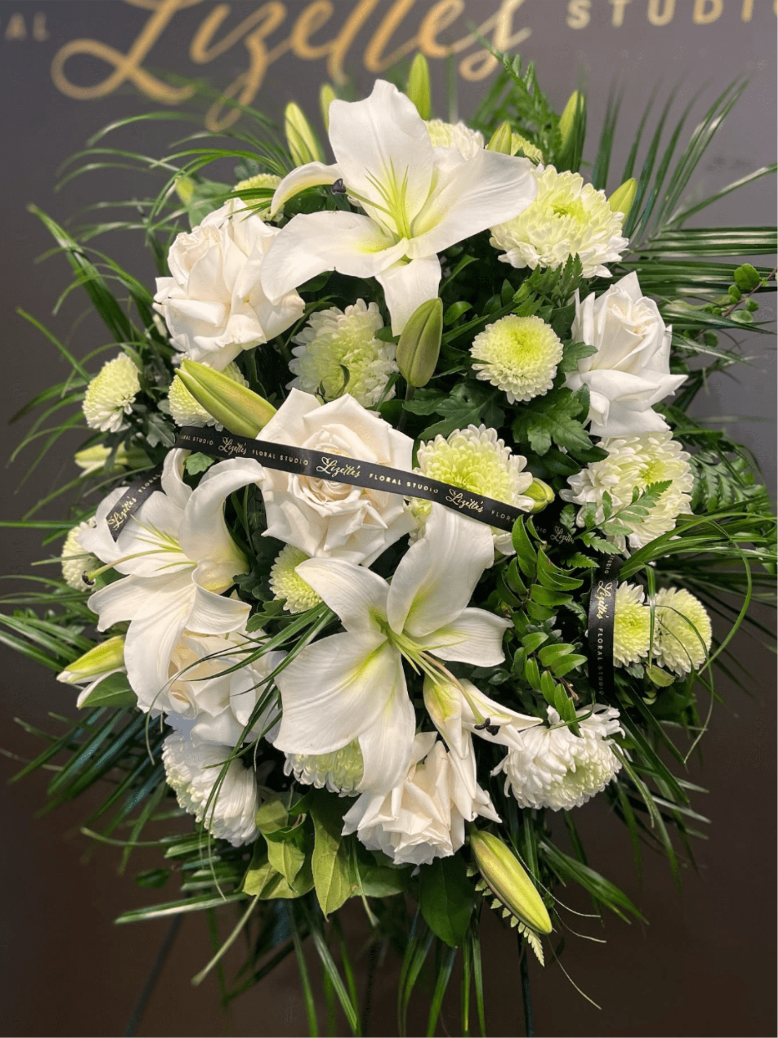 White lilies and roses with pale green mums in a floral spray