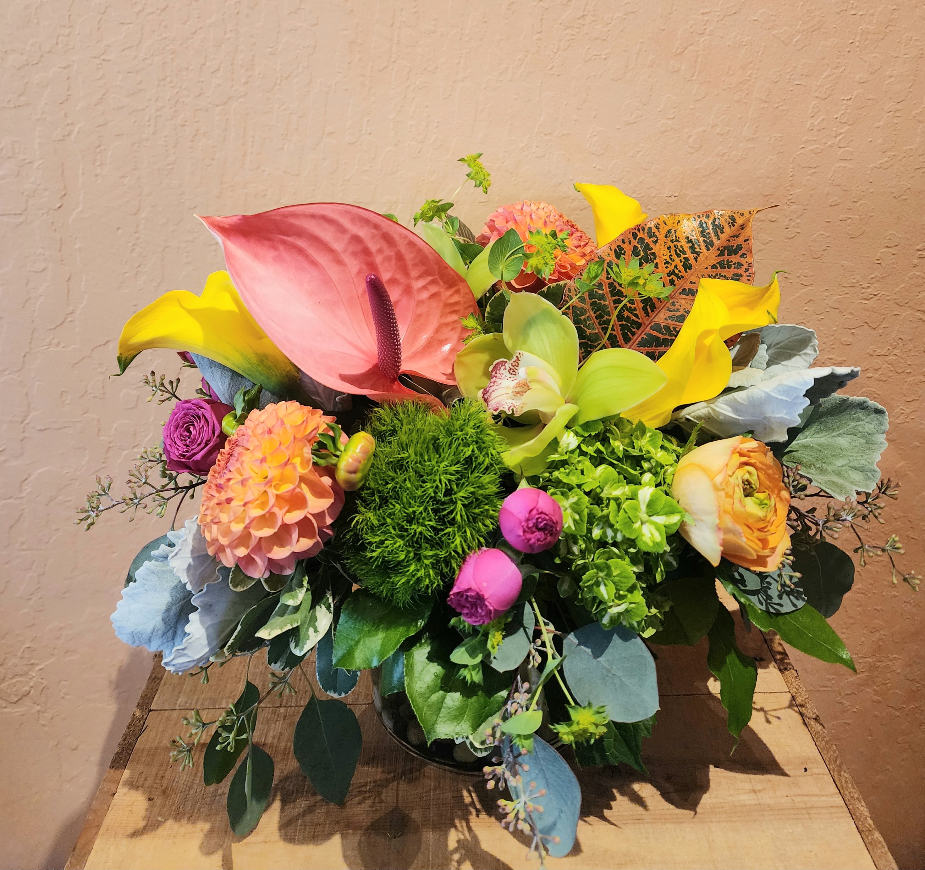 Colorful mixed floral arrangement with calla lilies, anthurium, and dahlias in a vase