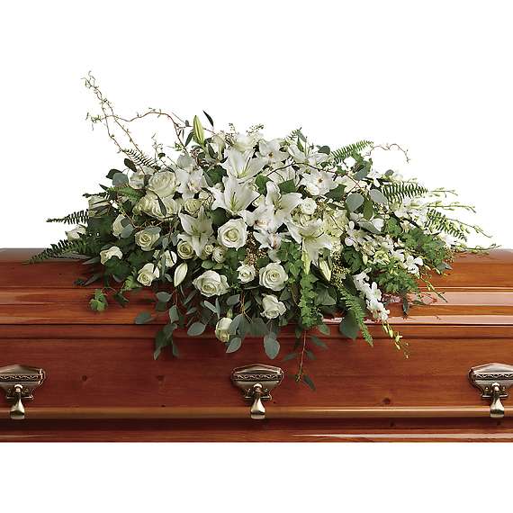 White floral spray on a wooden casket